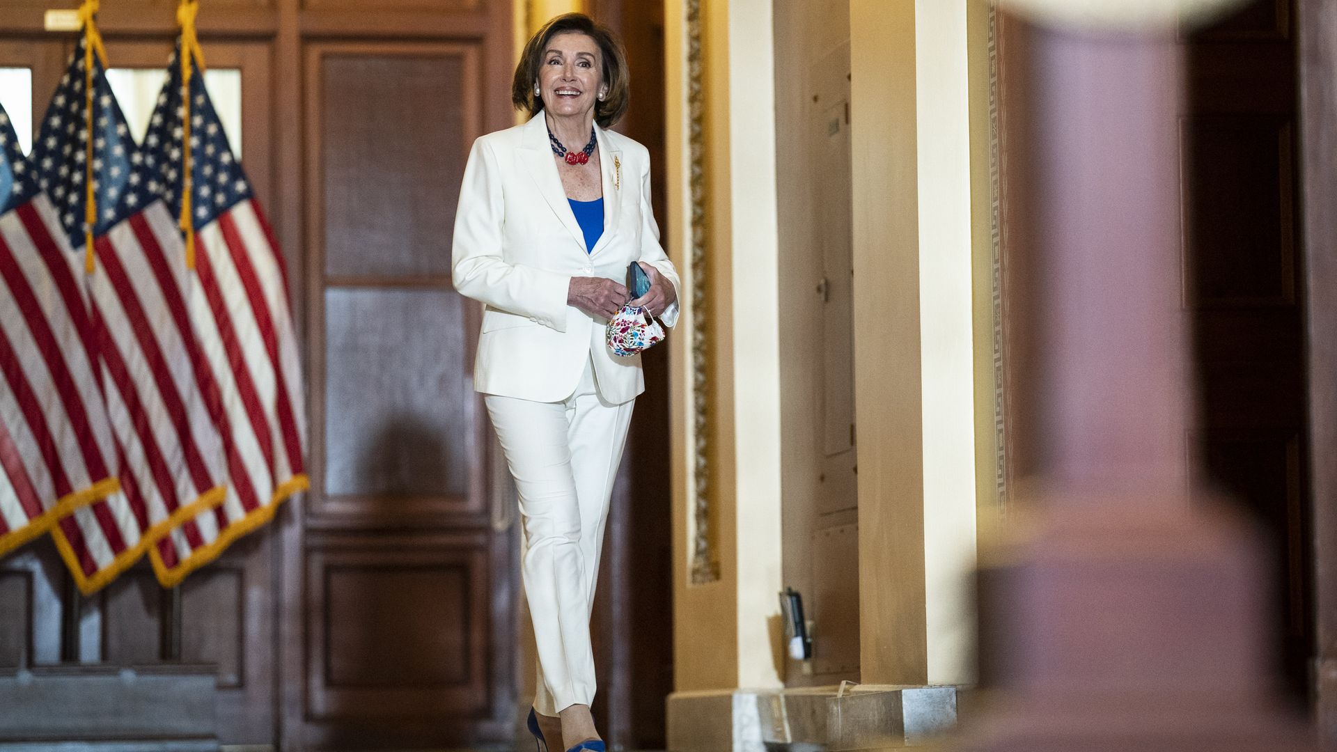 House Speaker Nancy Pelosi is seen smiling as she walks through the U.S. Capitol.