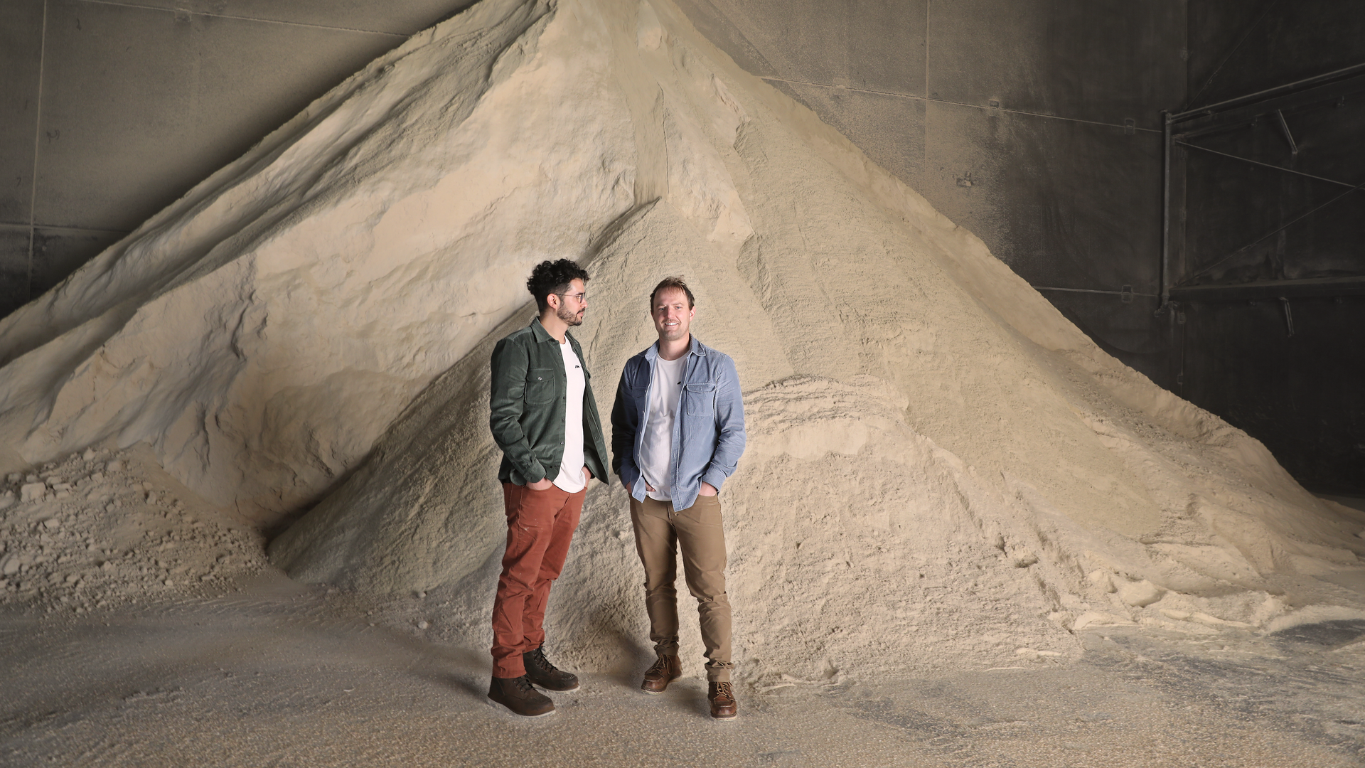 Loamist co-founders standing in front of rice husk waste.