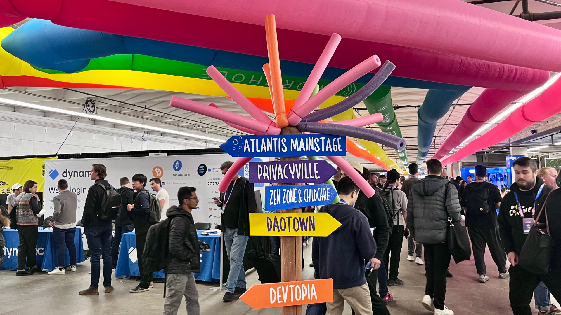 Image of a buzzing conference with colorful wayfinding. 