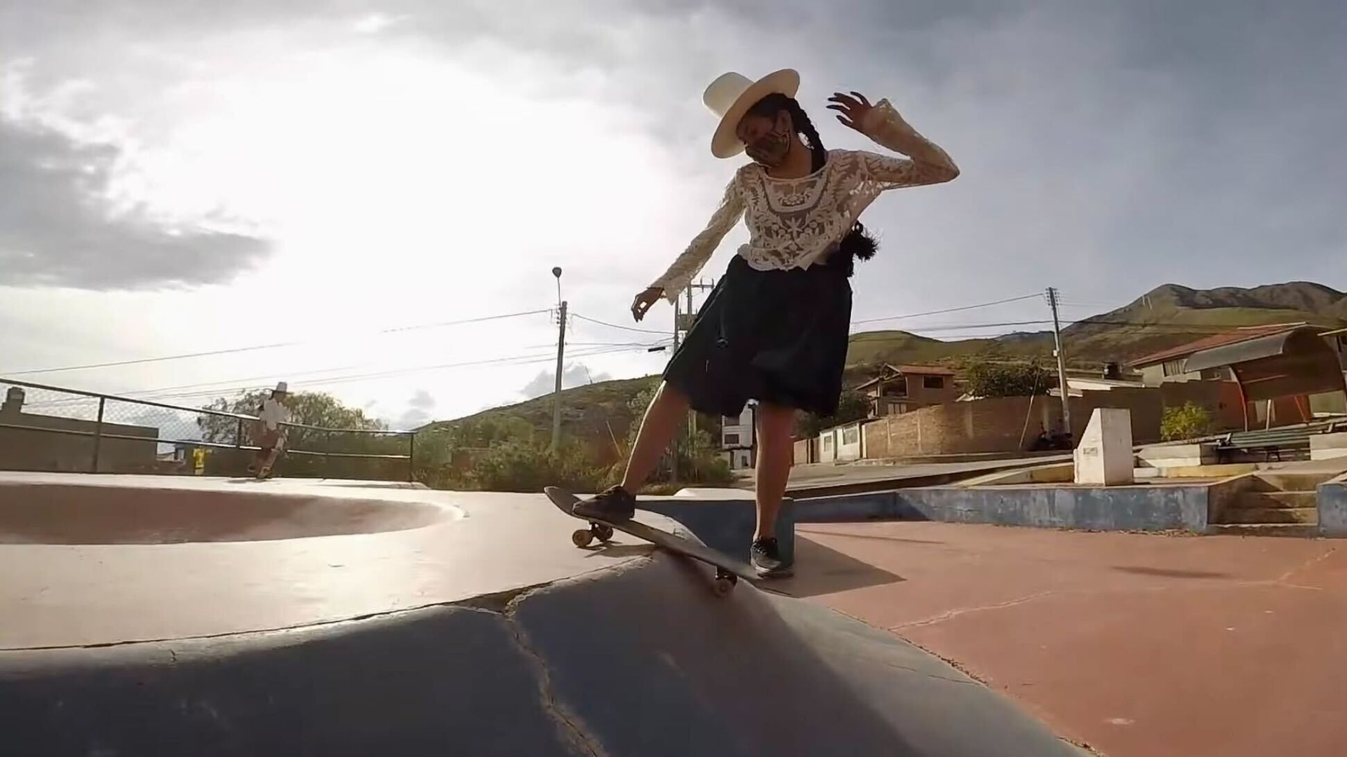 A Bolivian woman dressed in traditional Indigenous clothing on a skateboard