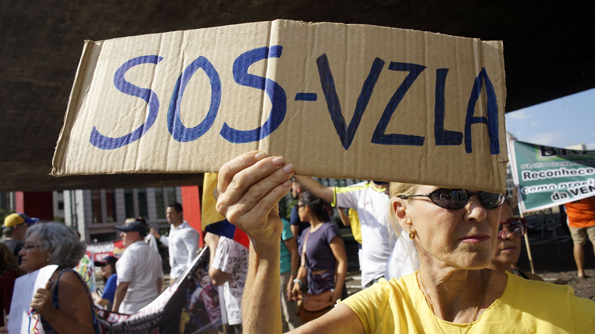 Woman holding SOS-Venezuela sign