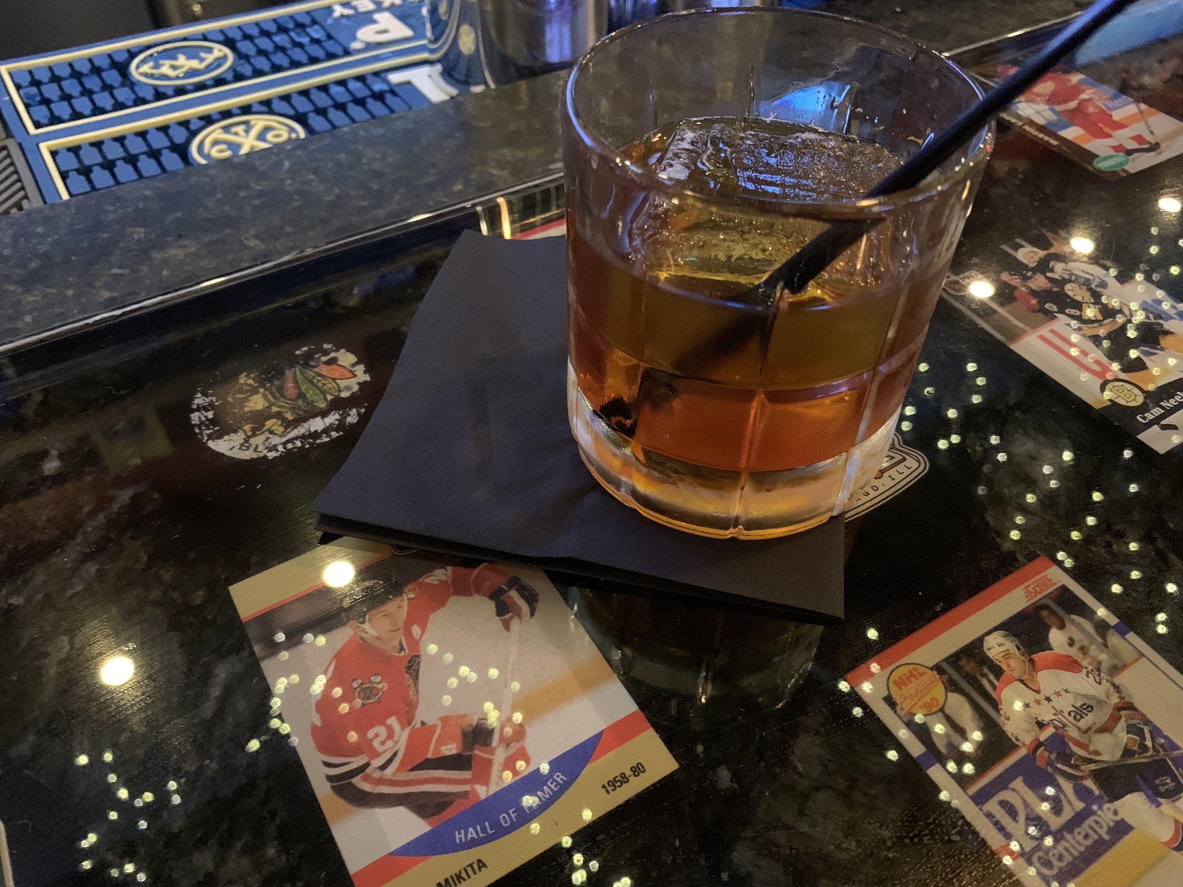 Photo of a cocktail sitting on a glass barr 