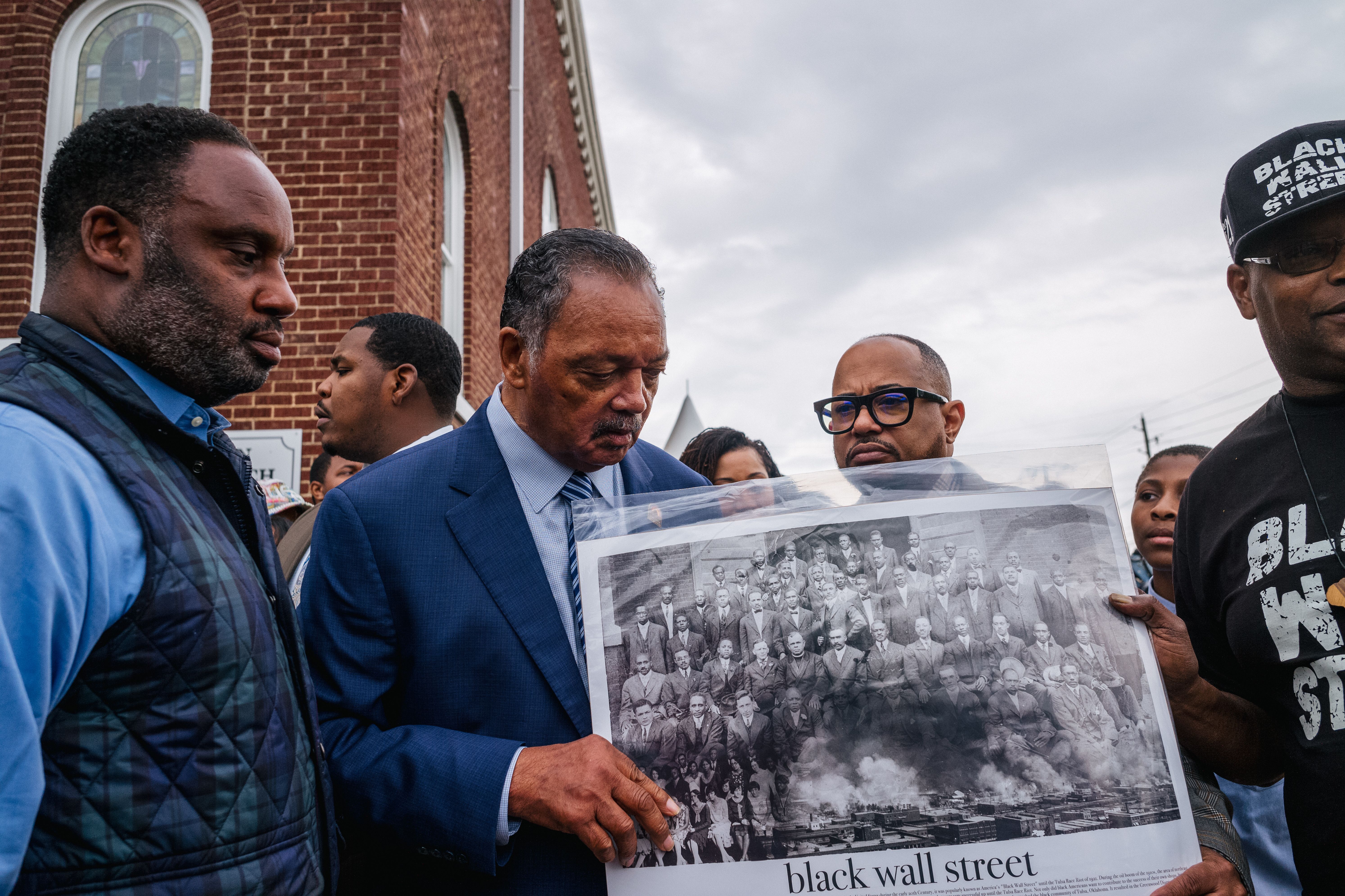 Rev. Jesse Jackson views a Black Wall Street poster board with residents at a Prayer Wall at the AME Church during commemorations for the Tulsa Race Massacre on May 31, 2021 in Tulsa, Oklahoma. 