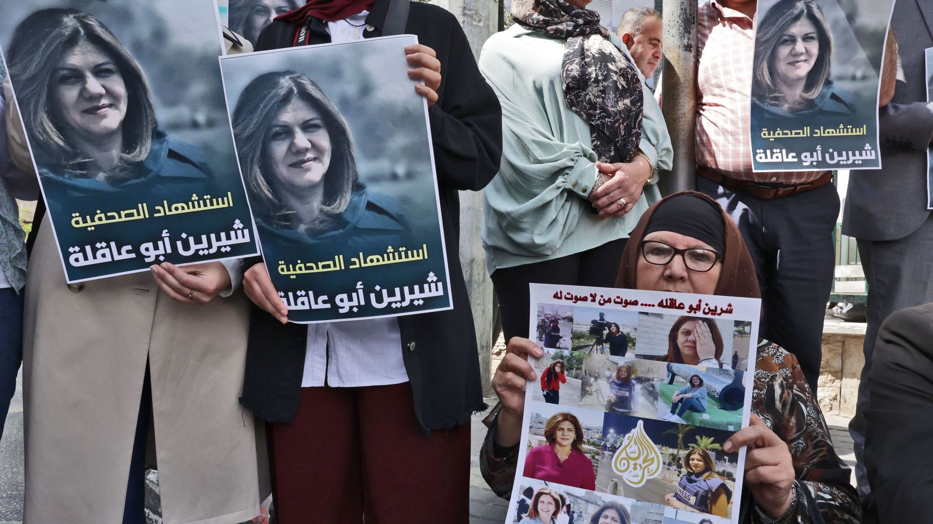 Palestinians hold posters displaying veteran Al Jazeera journalist Shireen Abu Akleh.