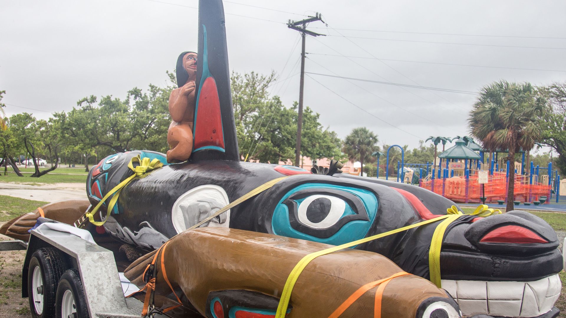 A hand carved whale totem on top of a car.