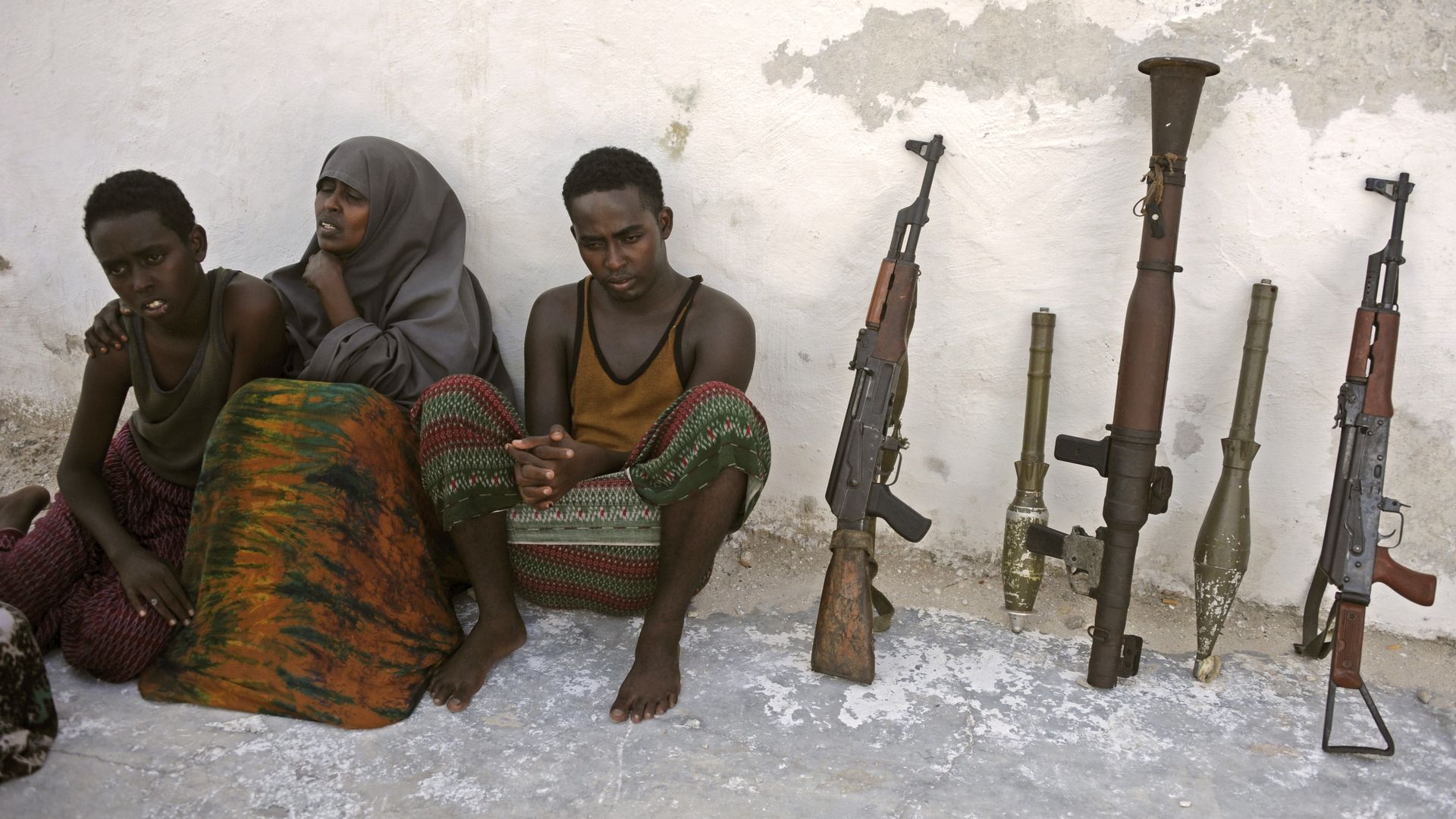 Suspected Al Qaeda-aligned Shabaab militants, a woman and her three children, sit next to weapons after their arrest on May 5, 2016 in Mogadishu