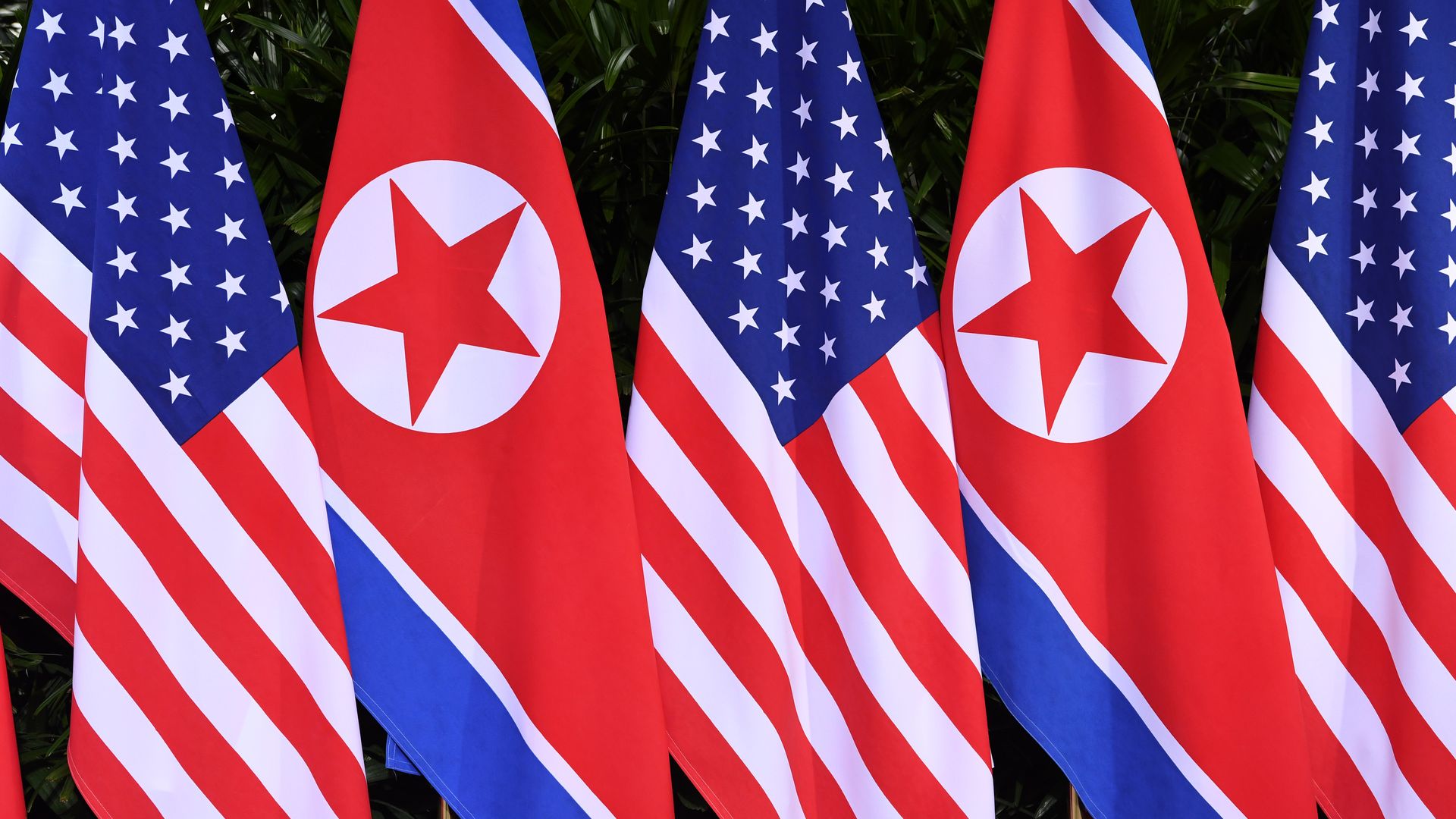 U.S. and N.K. flags flying by one another.