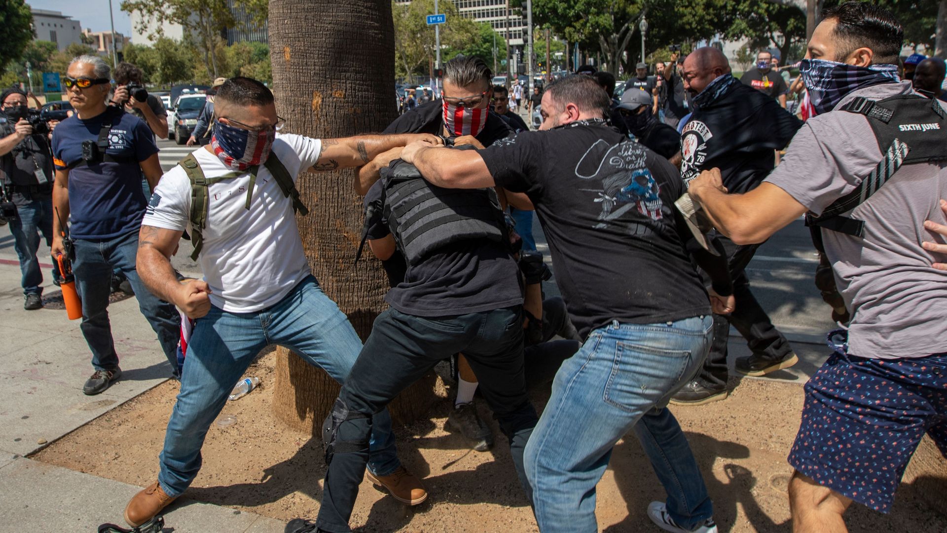Anti-vaccination protesters beat up a counter protester during an anti-vaccination rally near City Hall in Los Angeles on Aug. 14