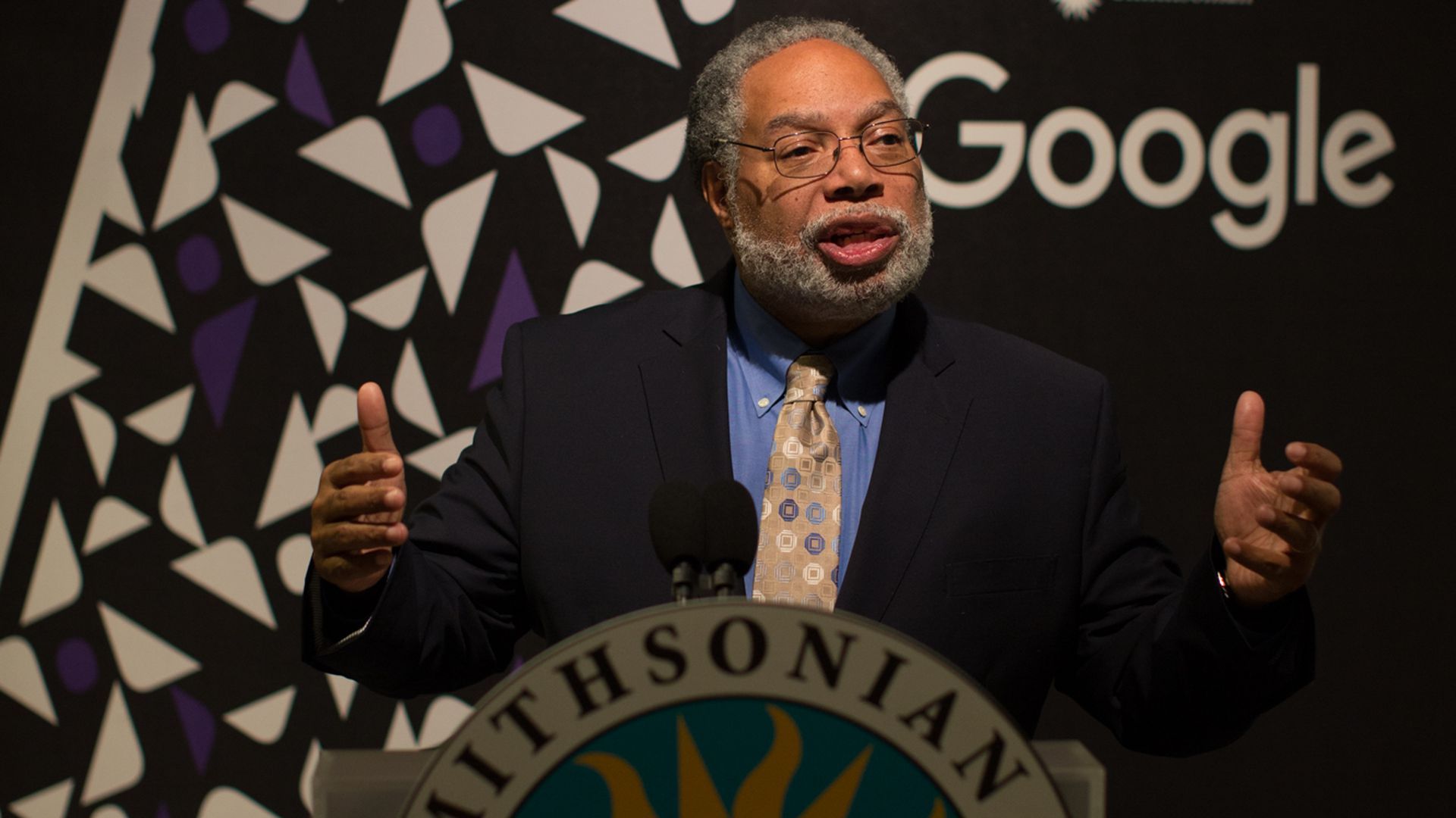Lonny Bunch, founding director of the Smithsonian's National Museum of African American History and Culture, speaking at a podium