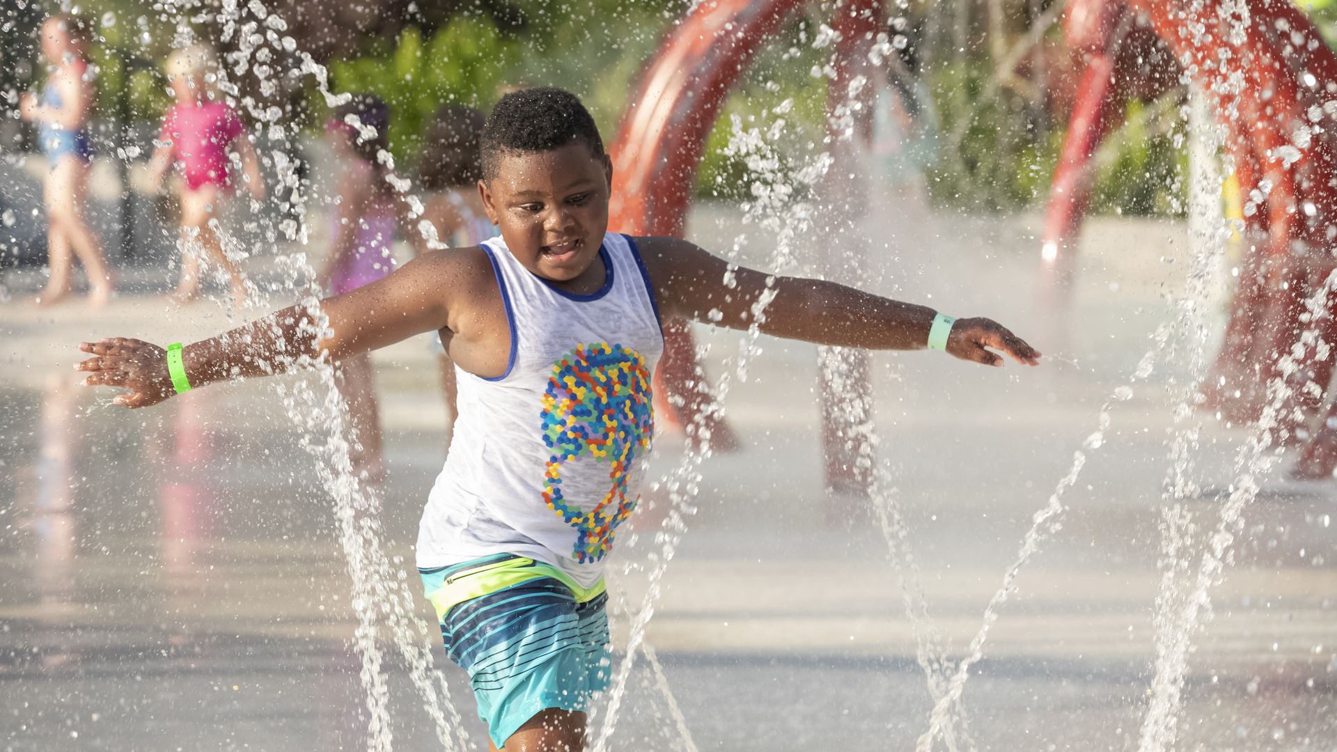 Photos shows a boy playing at a splash park.