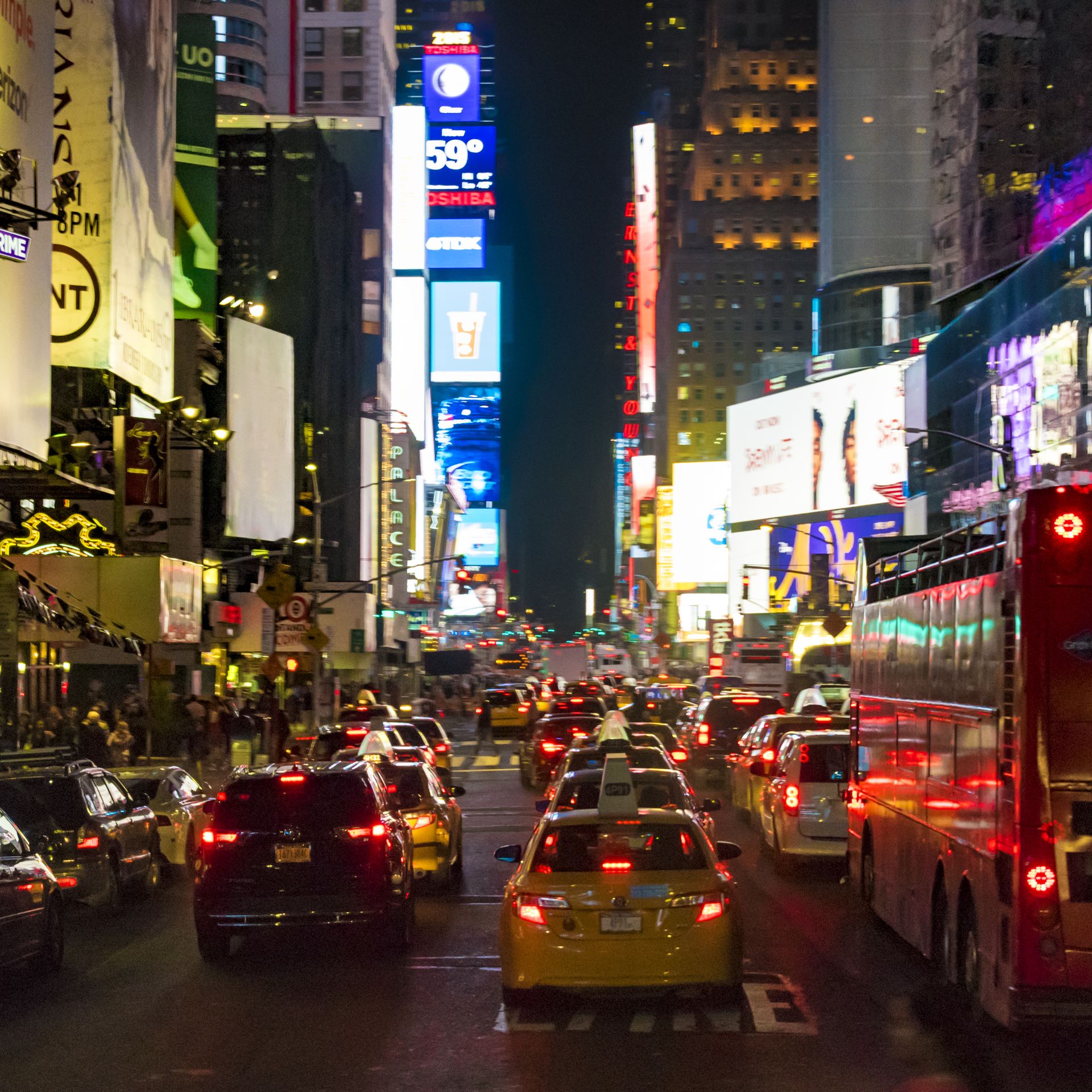 Night view of Times Square in New York City with cars in traffic