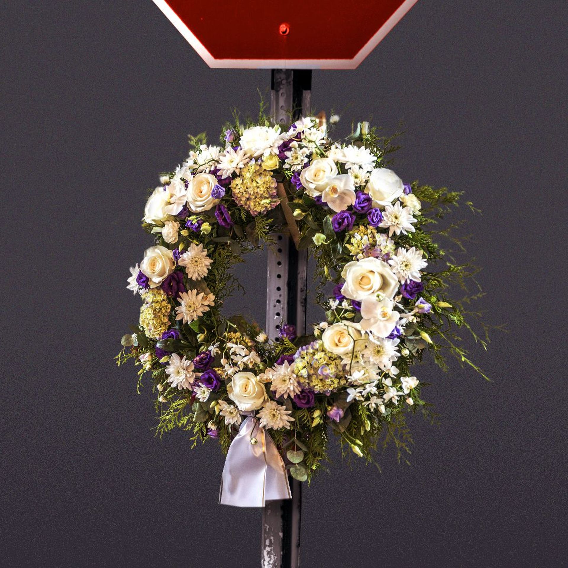 Illustration of a stop sign with a memorial wreath. 