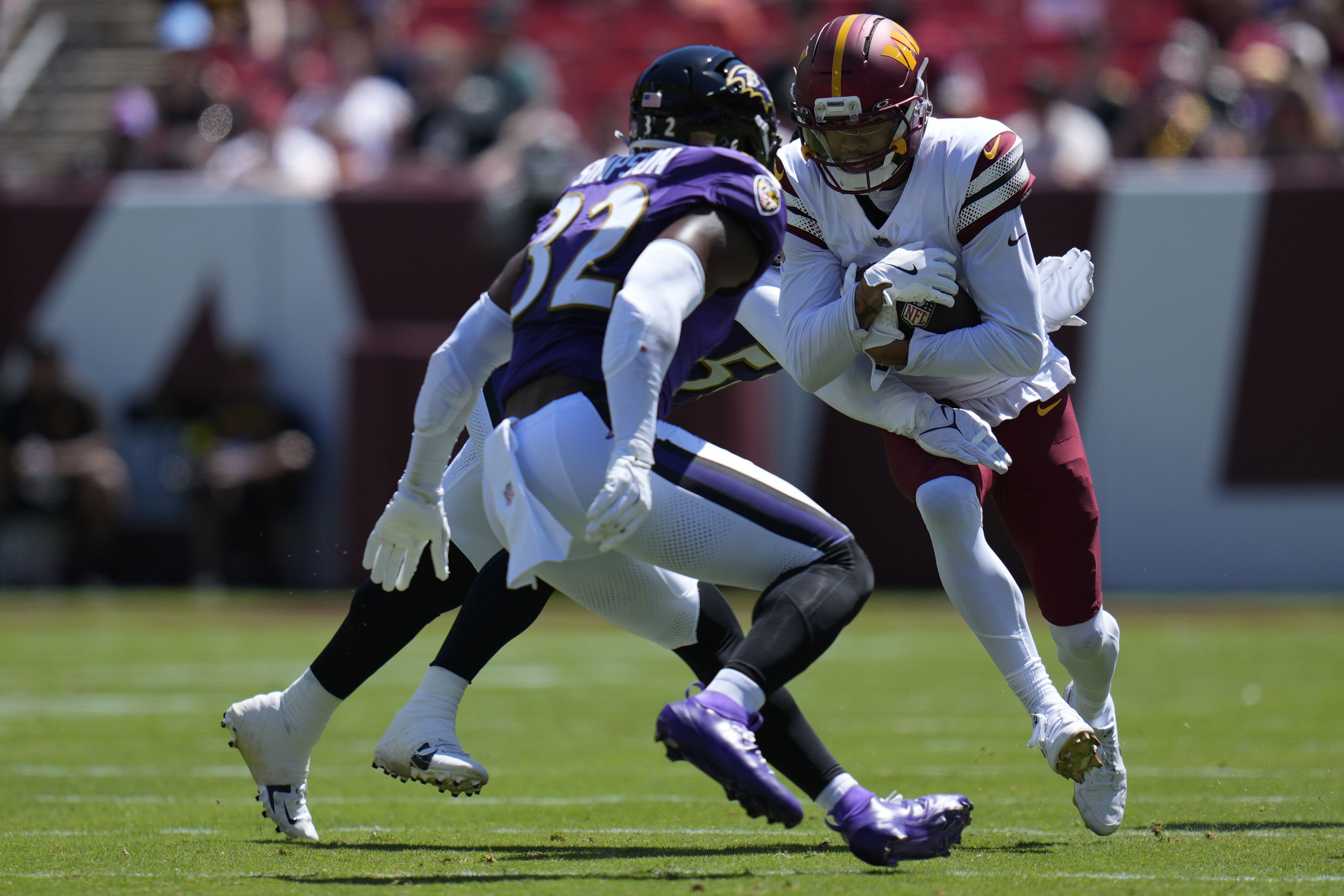 Chris Moore #19 of the Washington Commanders runs with the ball as Kaimon Rucker #56 and Trenton Simpson #32 of the Baltimore Ravens tackle during the NFL Preseason 2025 game at Northwest Stadium on August 23, 2025 in Landover, Maryland. (Photo by Jess Rapfogel/Getty Images)