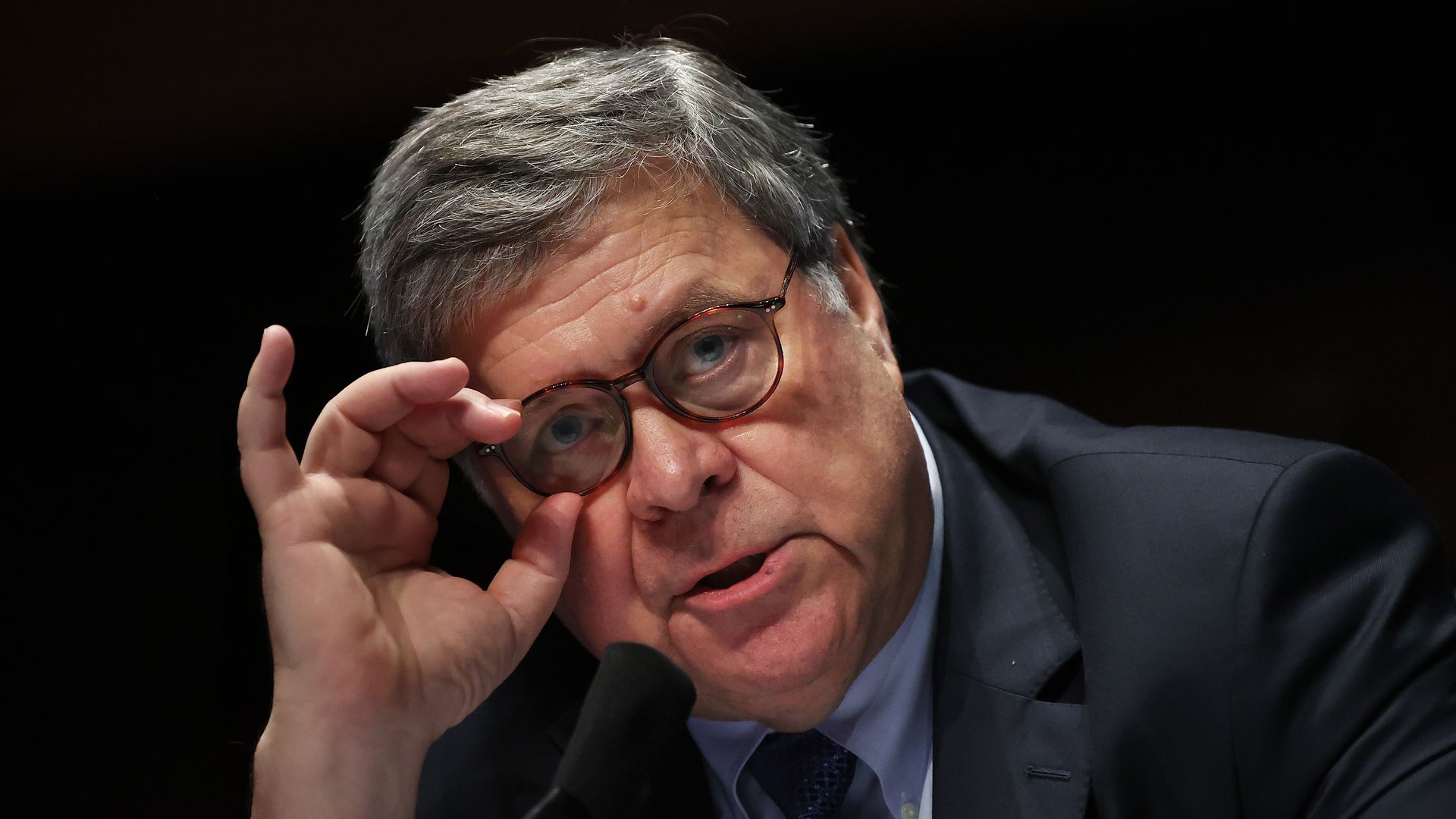 Bill Barr adjusts his glasses