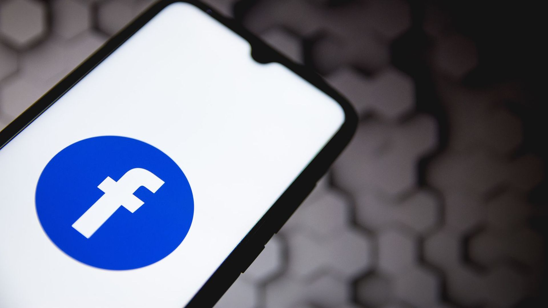 A photo illustration of the Facebook logo on a smartphone.
