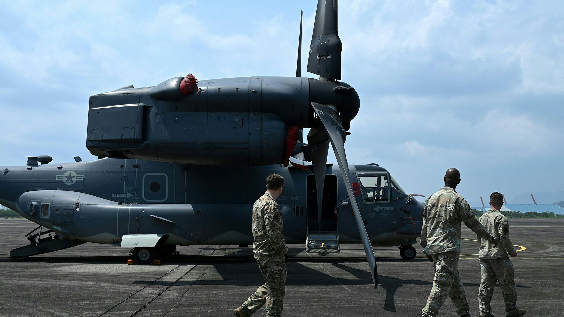 US soldiers walk past a parked CV-22 Osprey at Subic Bay Freeport Zone on April 23,