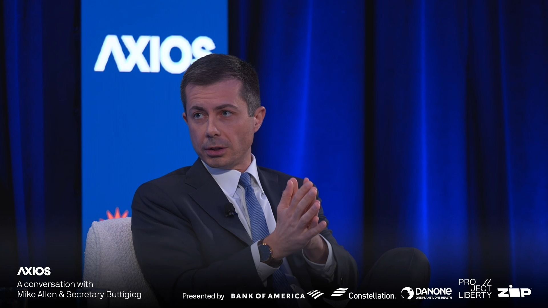 Buttigieg on stage with his hands clasped