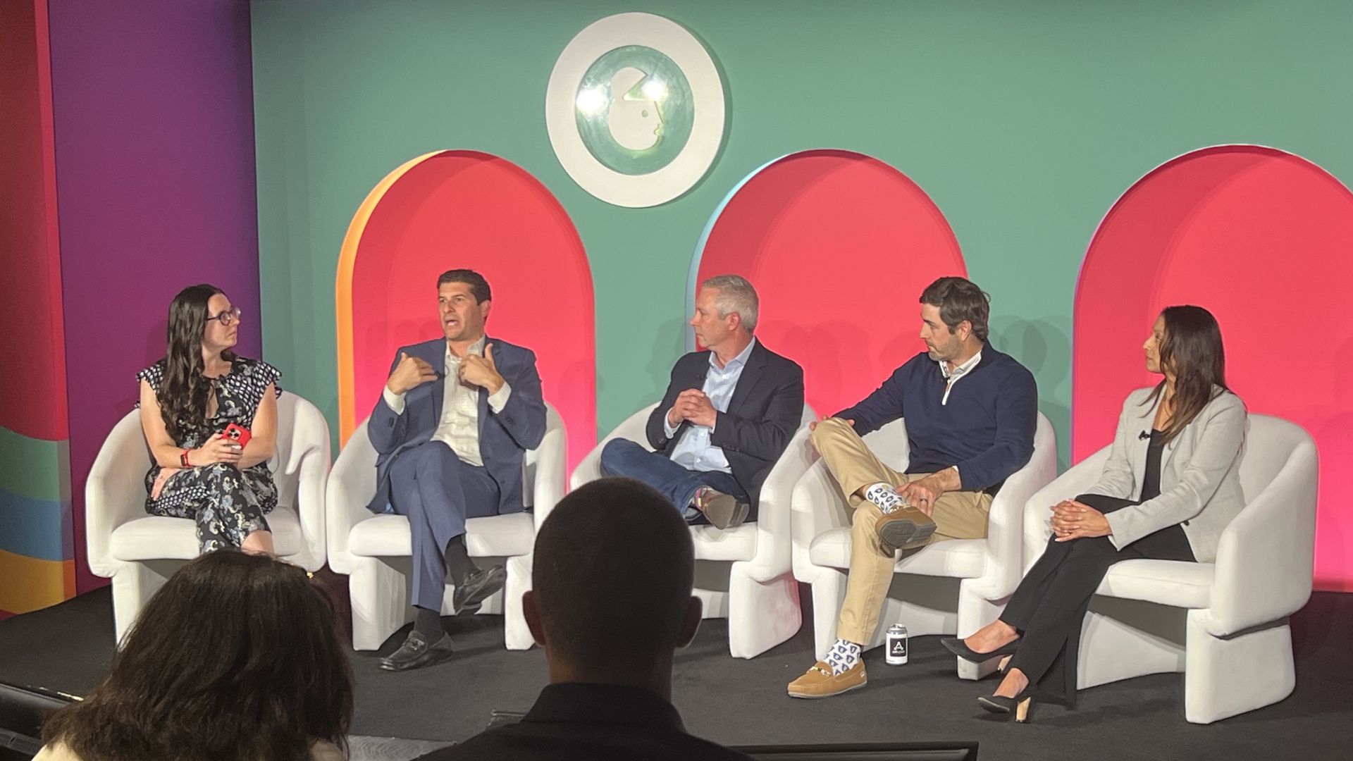 Kerry Flynn, DirecTV's Matt Van Houten, FreeWheel's Mark McKee, Yahoo's Beau Ordemann and TelevisaUnivision's Seema Patel seated in white chair on a stage with a green and pink background