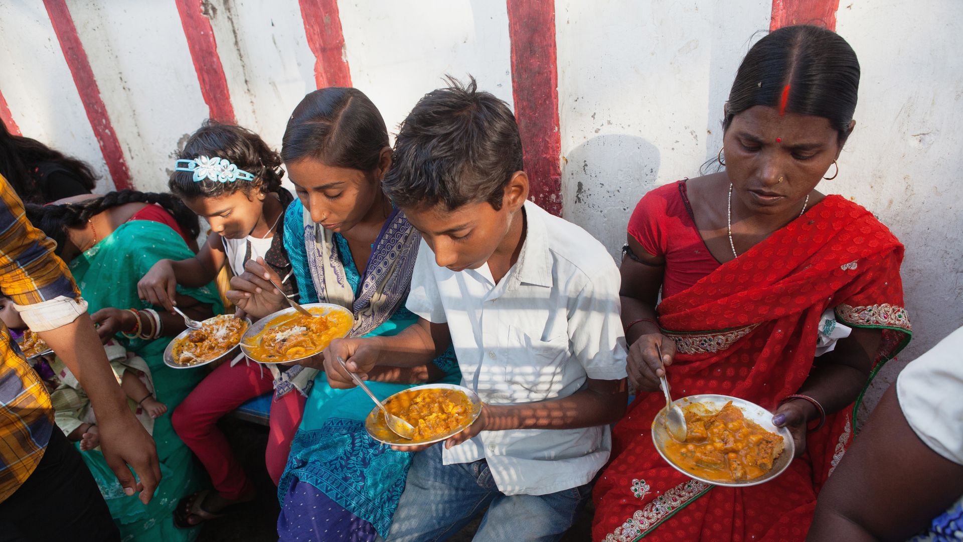 India, Bihar, Bodhgaya, A family eating vegetarian street food in Bodh. 