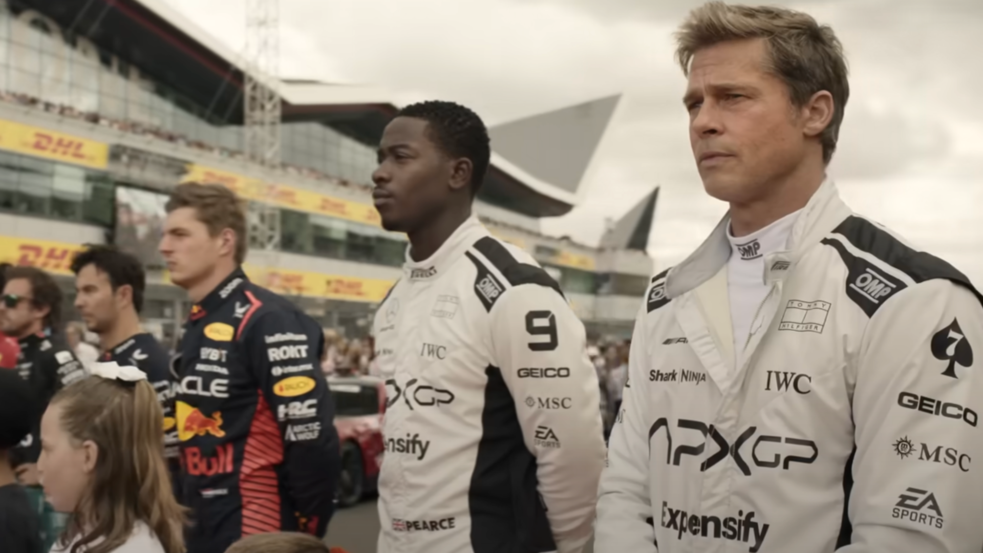 a still from a teaser for the Apple movie "F1" that features actor Brad Pitt in a driving uniform