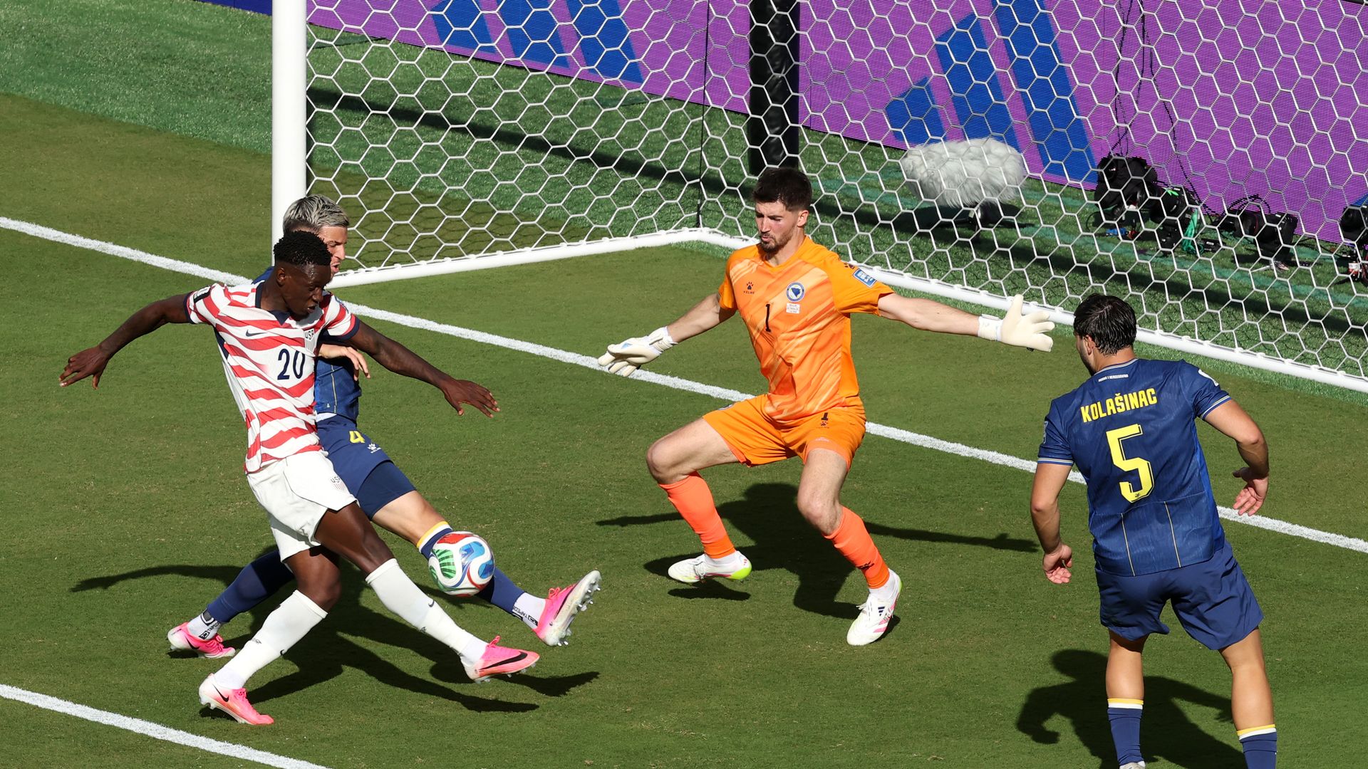 U.S. striker Folarin Balogun shoots the ball against three defenders from Bosnia-Herzegovina.