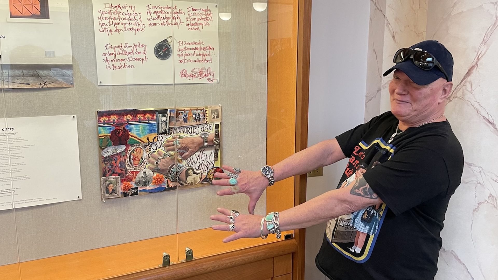 A photo of a person holding out their hands, showing their turquoise jewelry in front of an image of their hands.