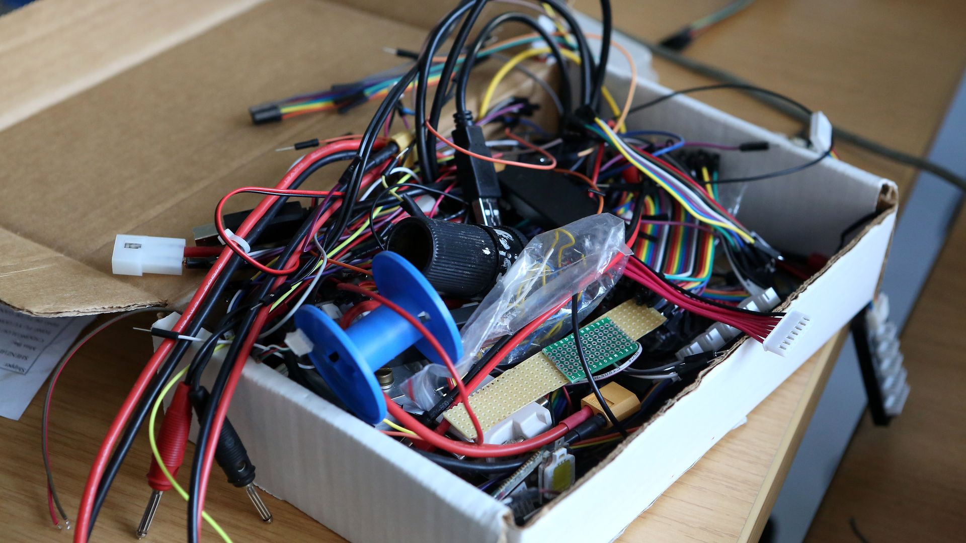 Photo of a cardboard box overflowing with electronic equipment