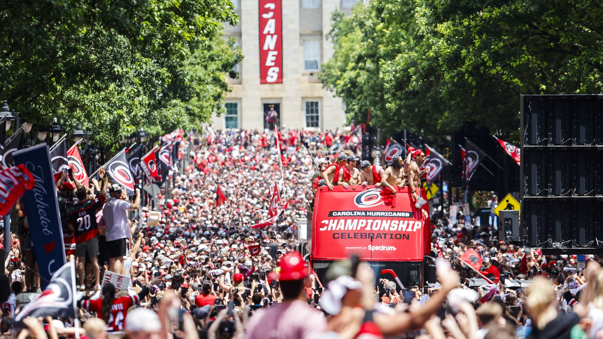 Players and staff ride in bus floats during the Carolina Hurricanes Stanley Cup Final Victory Parade in Raleigh.