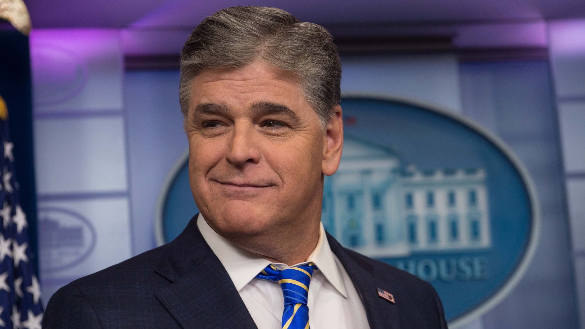 Fox News host Sean Hannity smirks in the White House briefing room 
