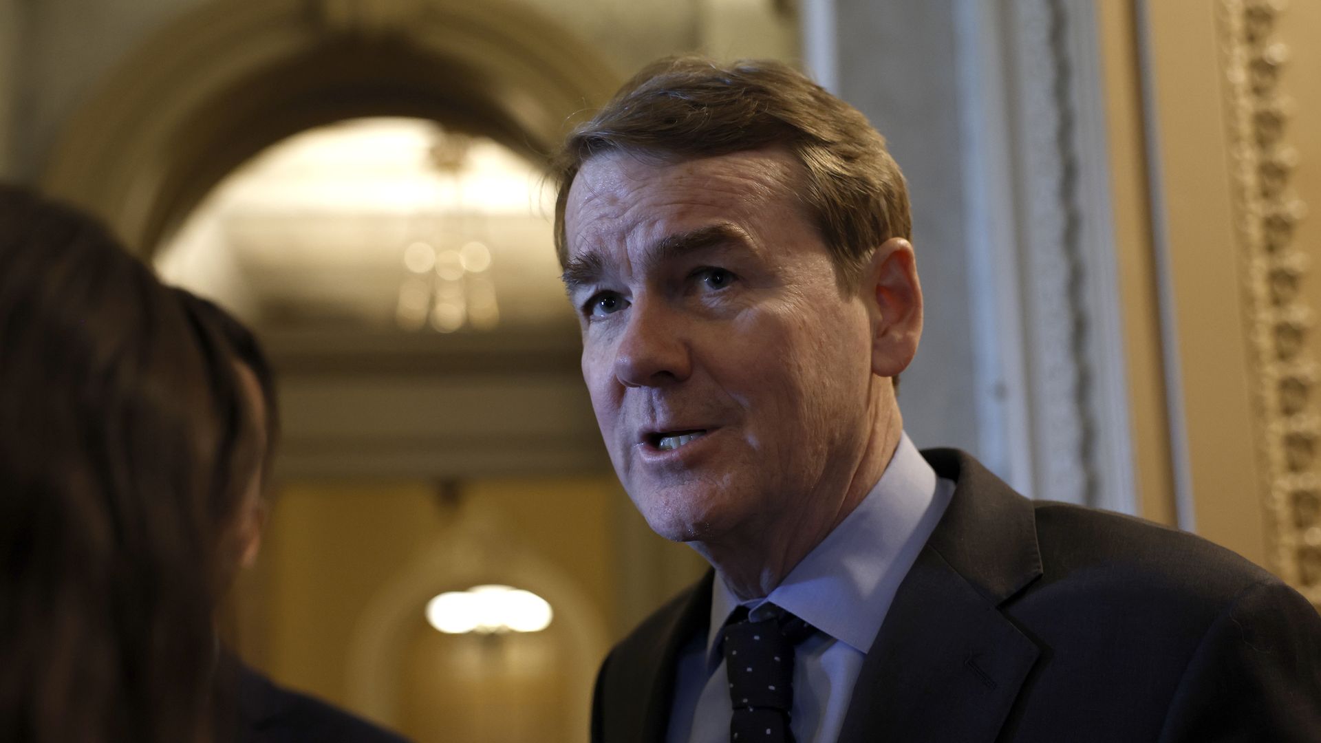 Senator Michael Bennet talks to reporters outside the Senate chamber