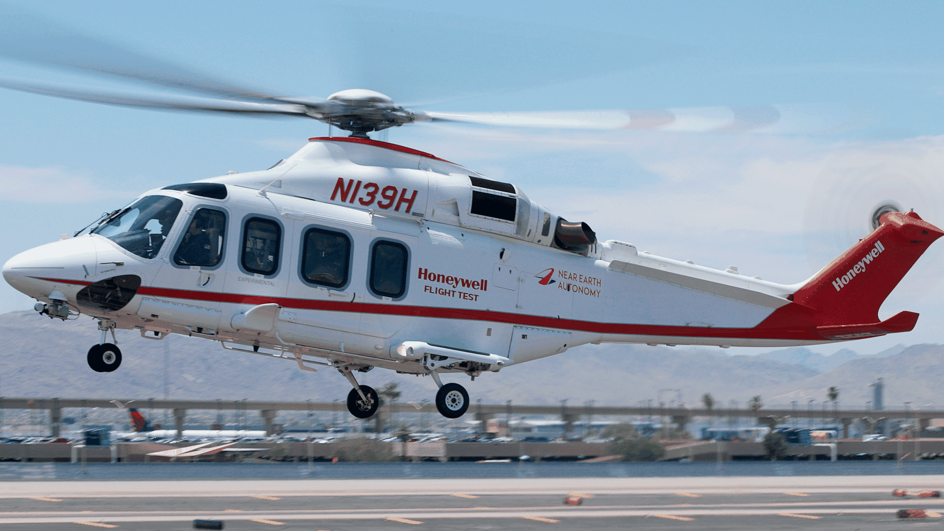 A helicopter lifts off from an airport tarmac.