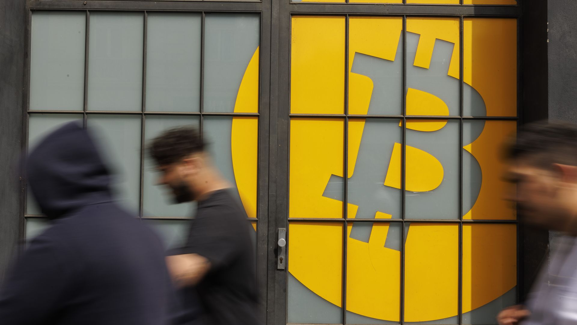 People walking past a Bitcoin logo in Prague, Czech Republic, in May 2022.
