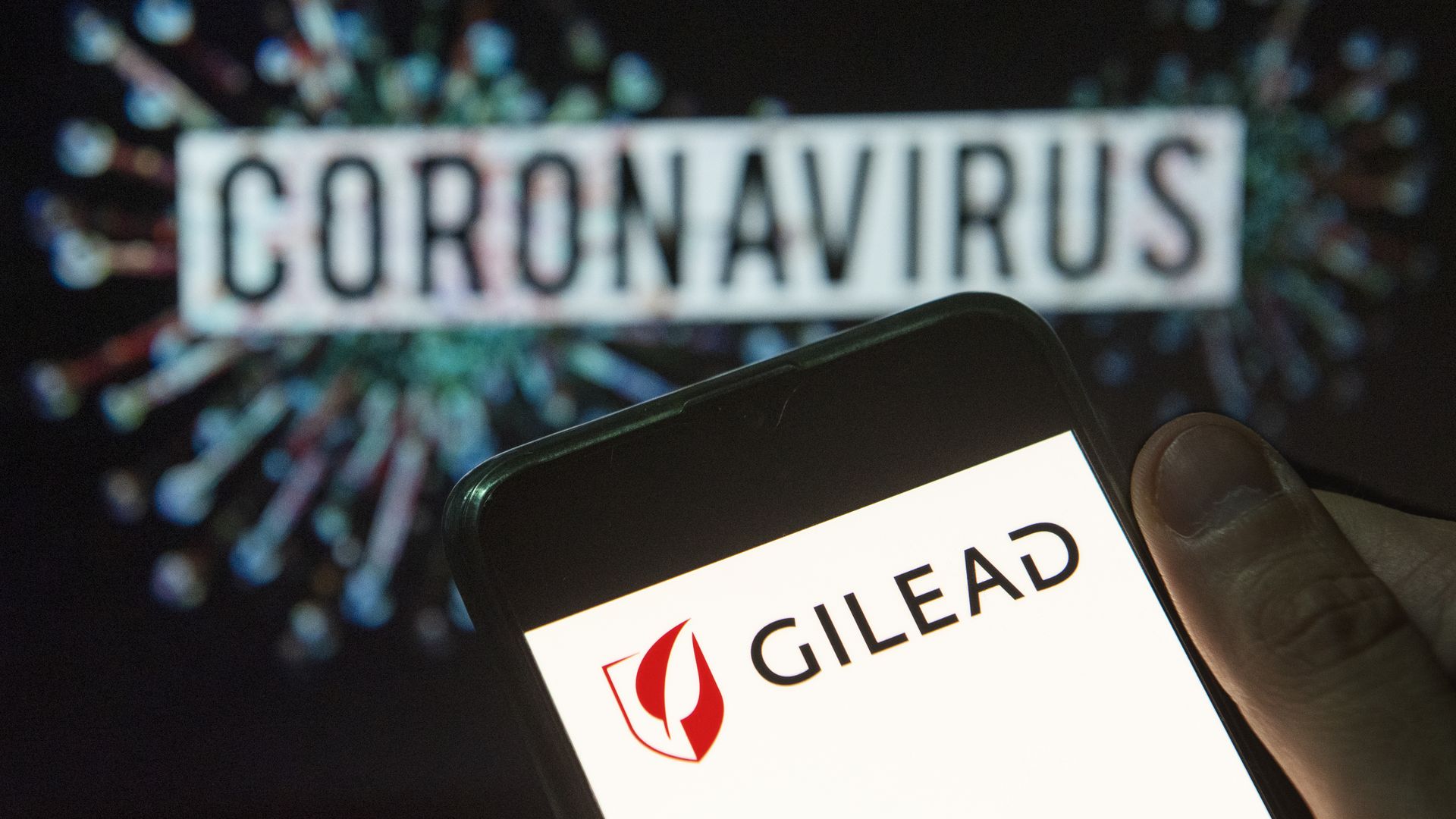 Gilead Science logo on a phone with the word "coronavirus" in the background