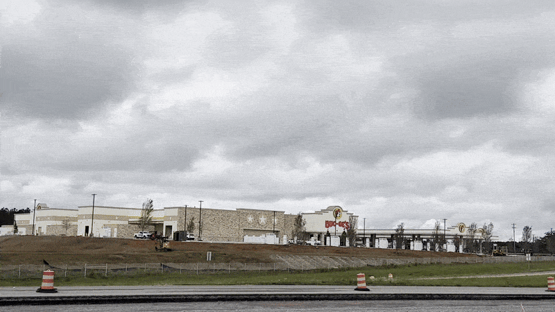 Image shows someone driving past Buc-ee's.