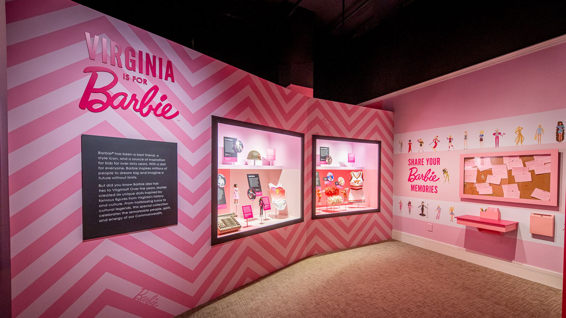 Exhibit room with pink chevron walls, glass display cases of Barbie items, and a large sign reads "Virginia is for Barbie." The right wall shows a "Share Your Barbie Memories" panel with drawings and a corkboard of notes.