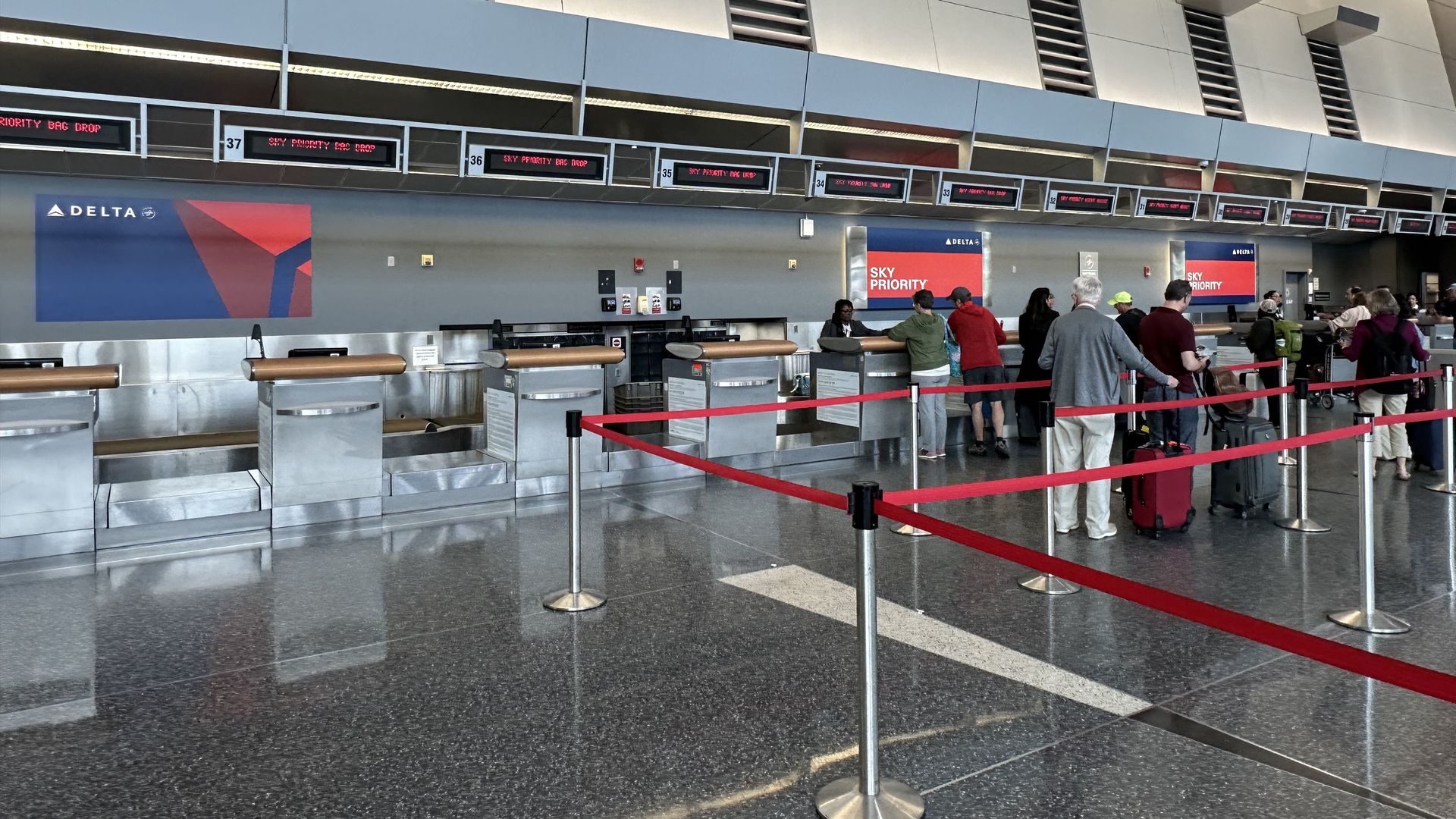 A small line of travelers line up behind the Delta Sky Priority windows at Logan Airport, days before the Memorial Day weekend travel rush.