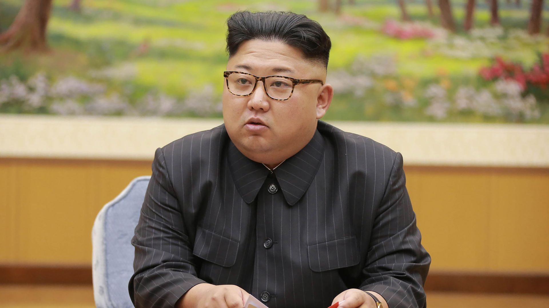 Kim Jong-un sits at a table