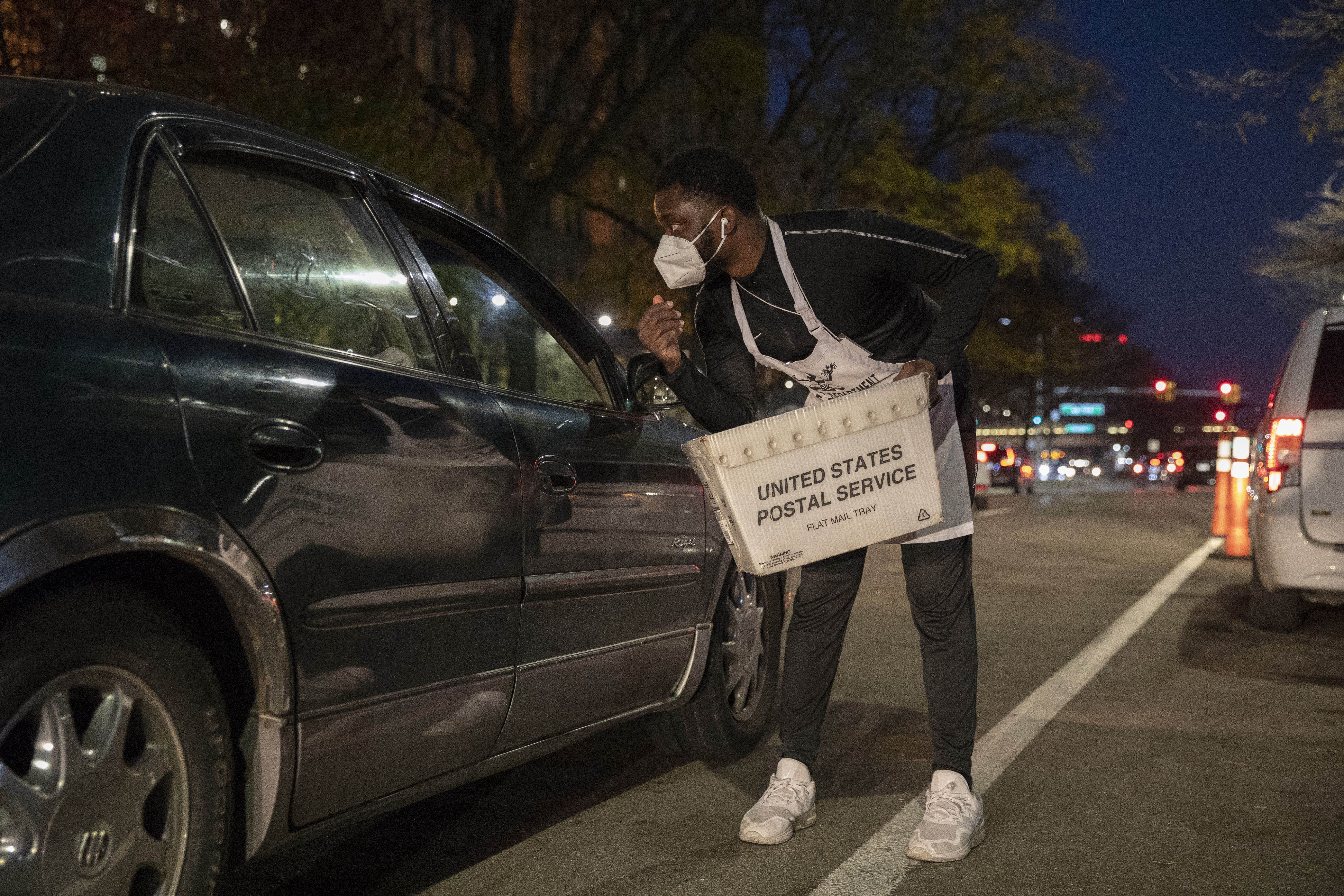 Steven Addo, 23, talks with someone dropping of an absentee ballot outside the Department of Elections on November 3, 2020 in Detroit, Michigan. 