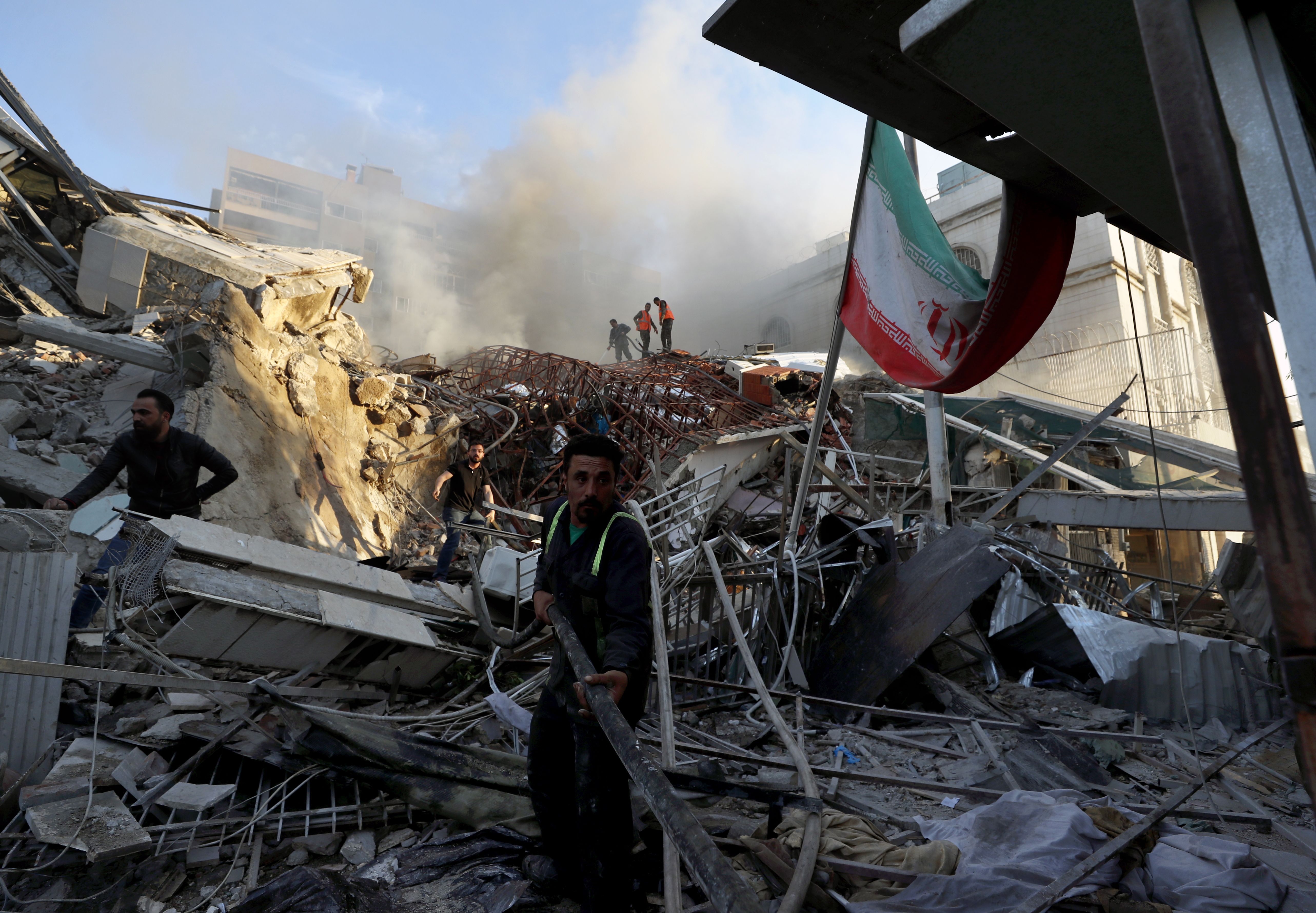 Workers remove debris at the Iranian embassy compound in Damascus, Syria, after an Israeli strike yesterday.