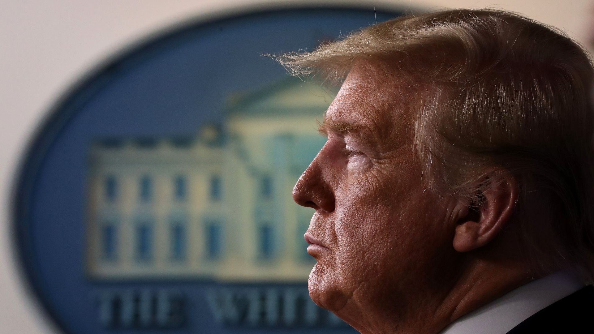 In this image, Trump stands in front of a White House sign