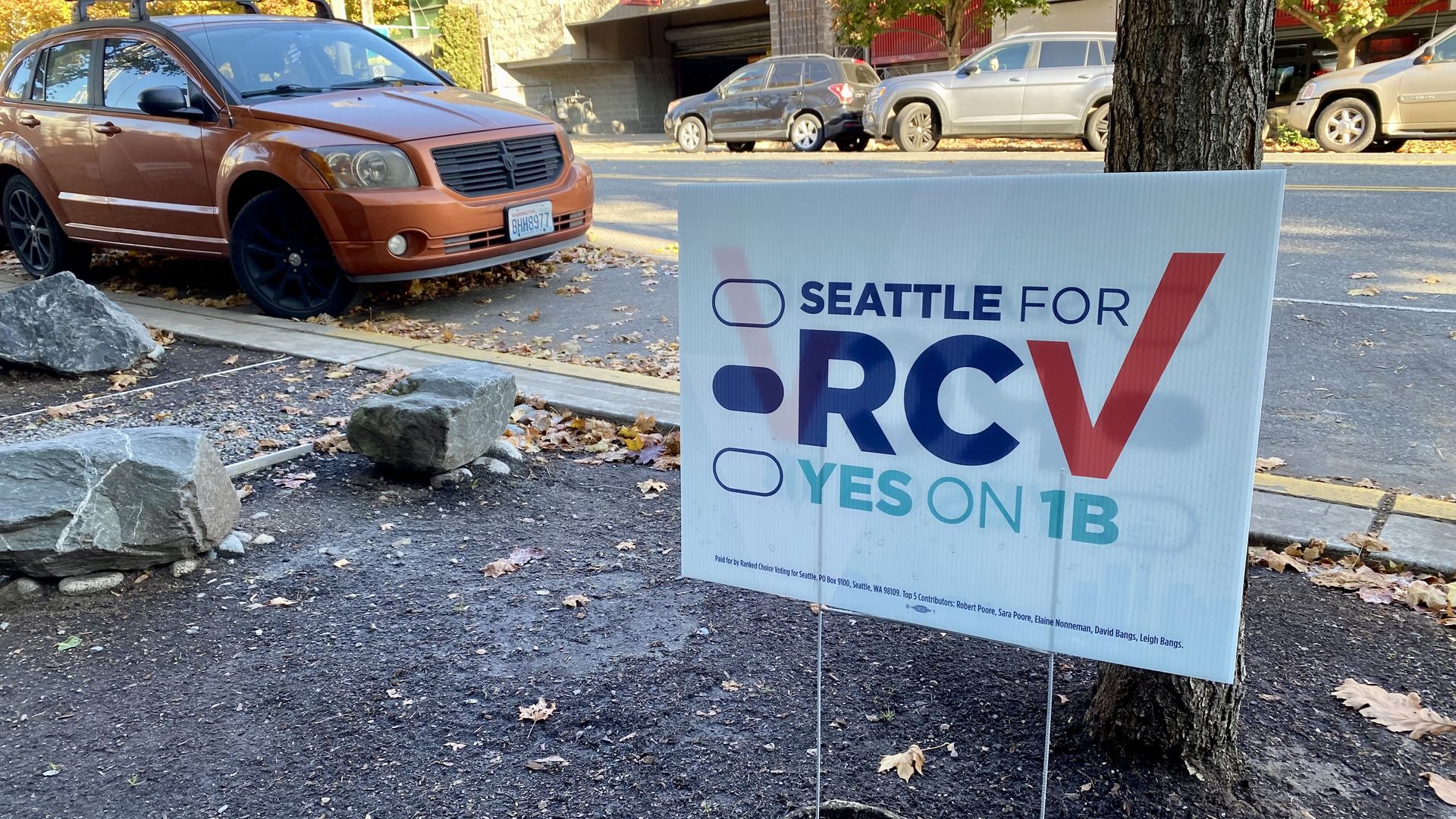 A yard sign along a sidewalk says "Seattle for RCV" and "Yes on 1B"