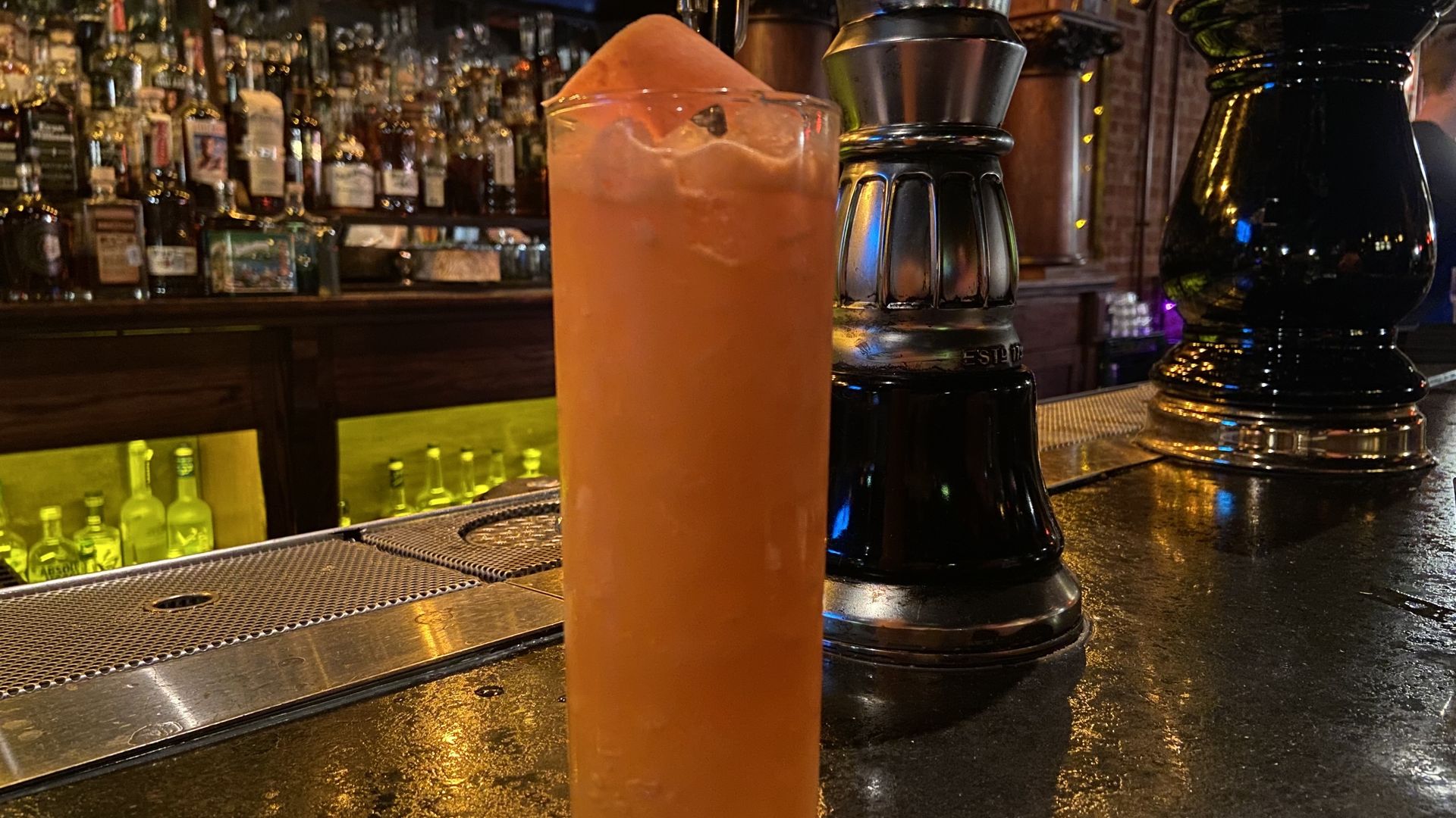 A carrot color drink on a bar