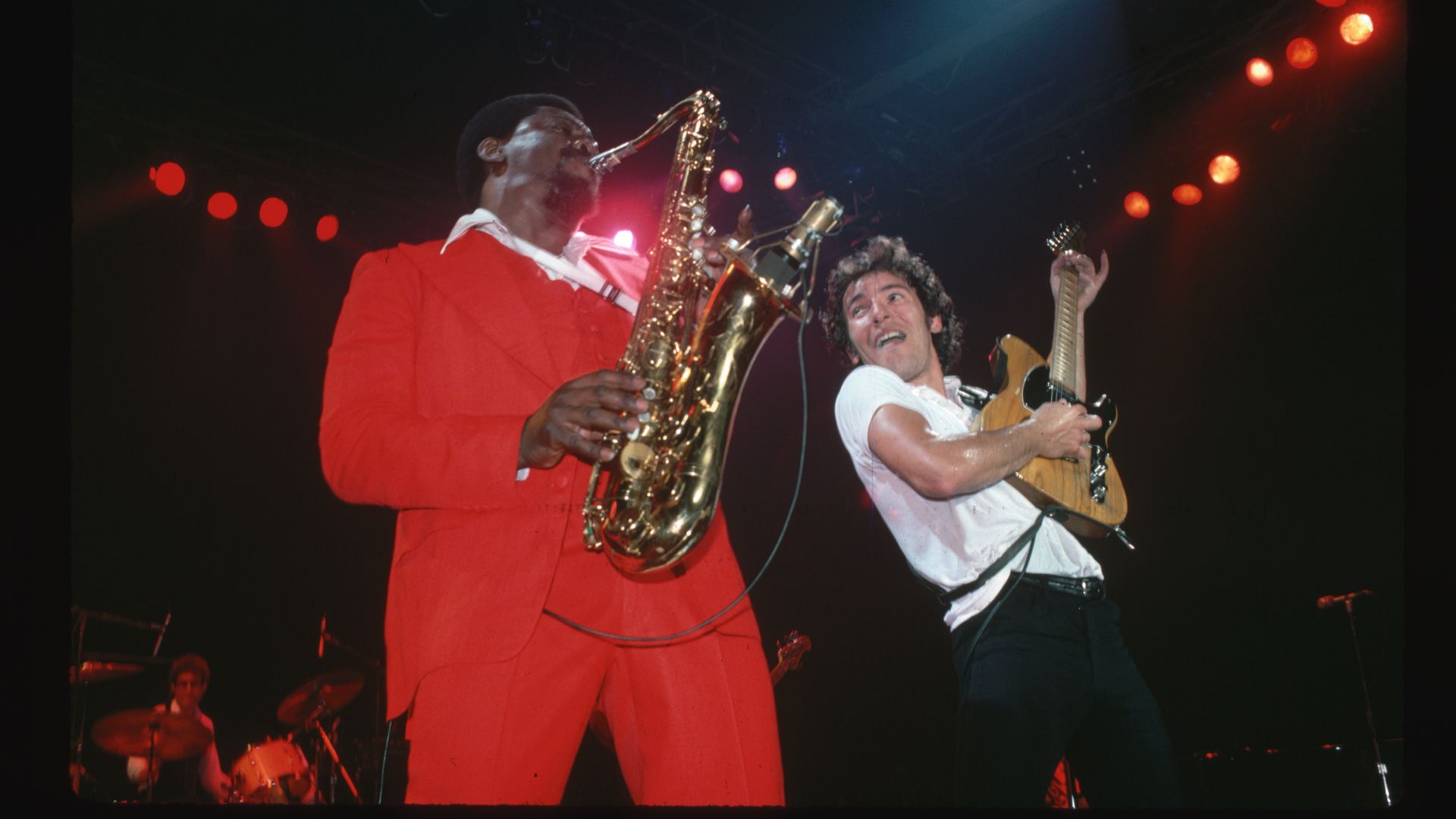 Rock and roll musician Bruce Springsteen and saxonphonist Clarence Clemmons playing in concert on stage. In the background can be seen drummer Max Weinberg.