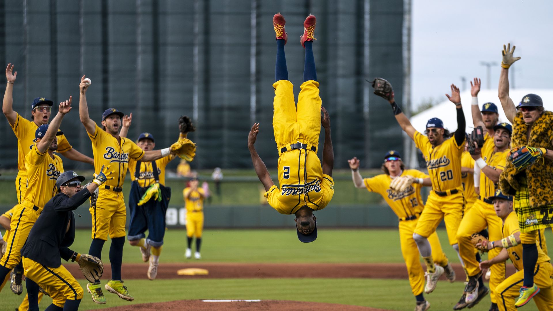 Savannah Banana Malachi Mitchell (2) flips in the air as the team cheers before the start of a banana ball game against the Kansas City Monarchs at Legends Field on Friday, May 6, 2022 in Kansas City, KS.