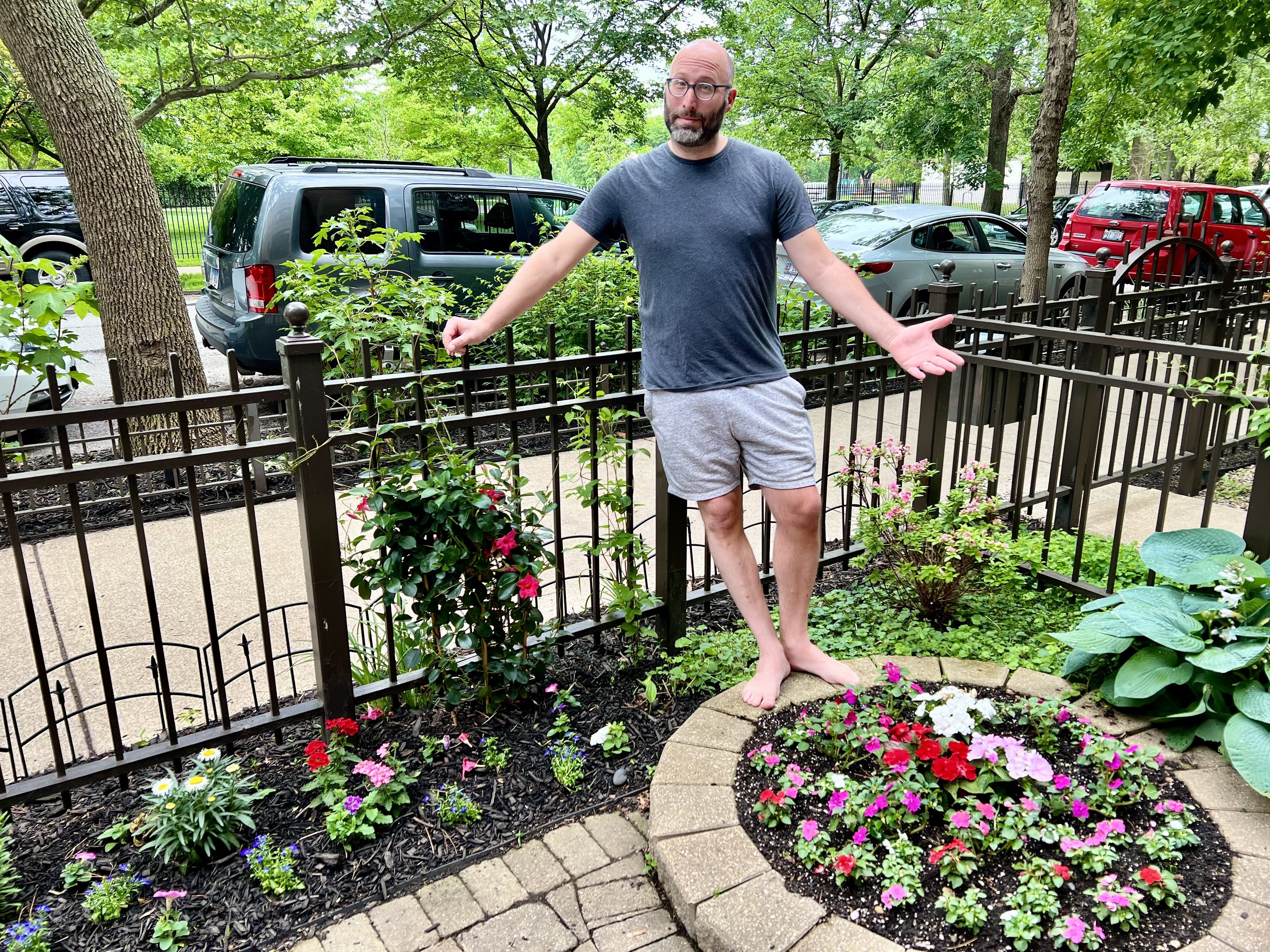 Photo of a man in his flower garden. 