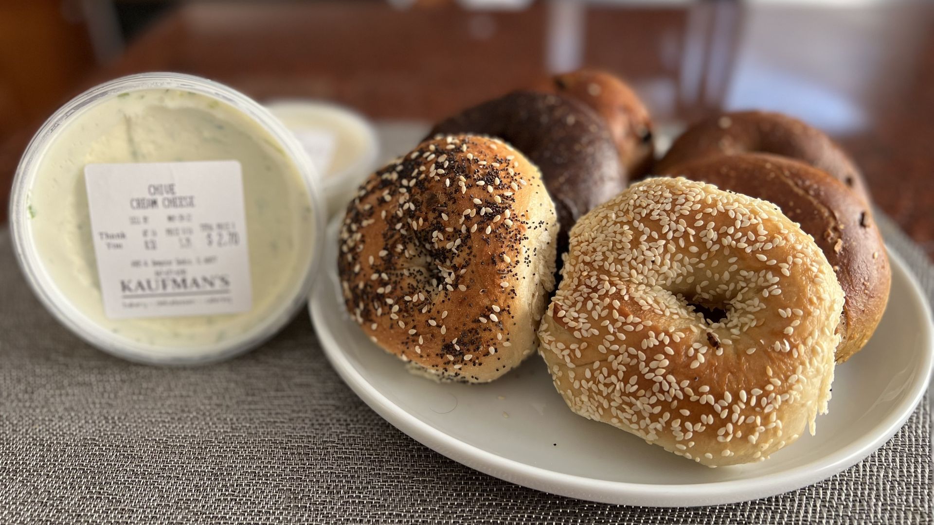 Photo of a plate of bagels with a package of cream cheese. 