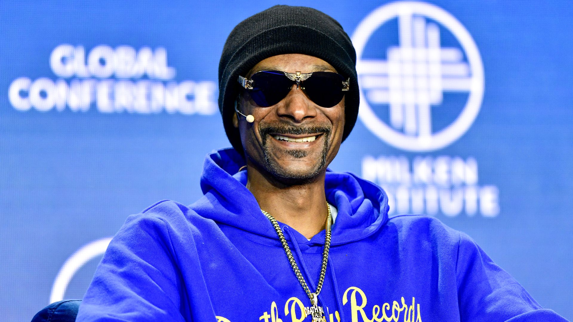 Snoop Dogg smiling in a Death Row Records shirt.