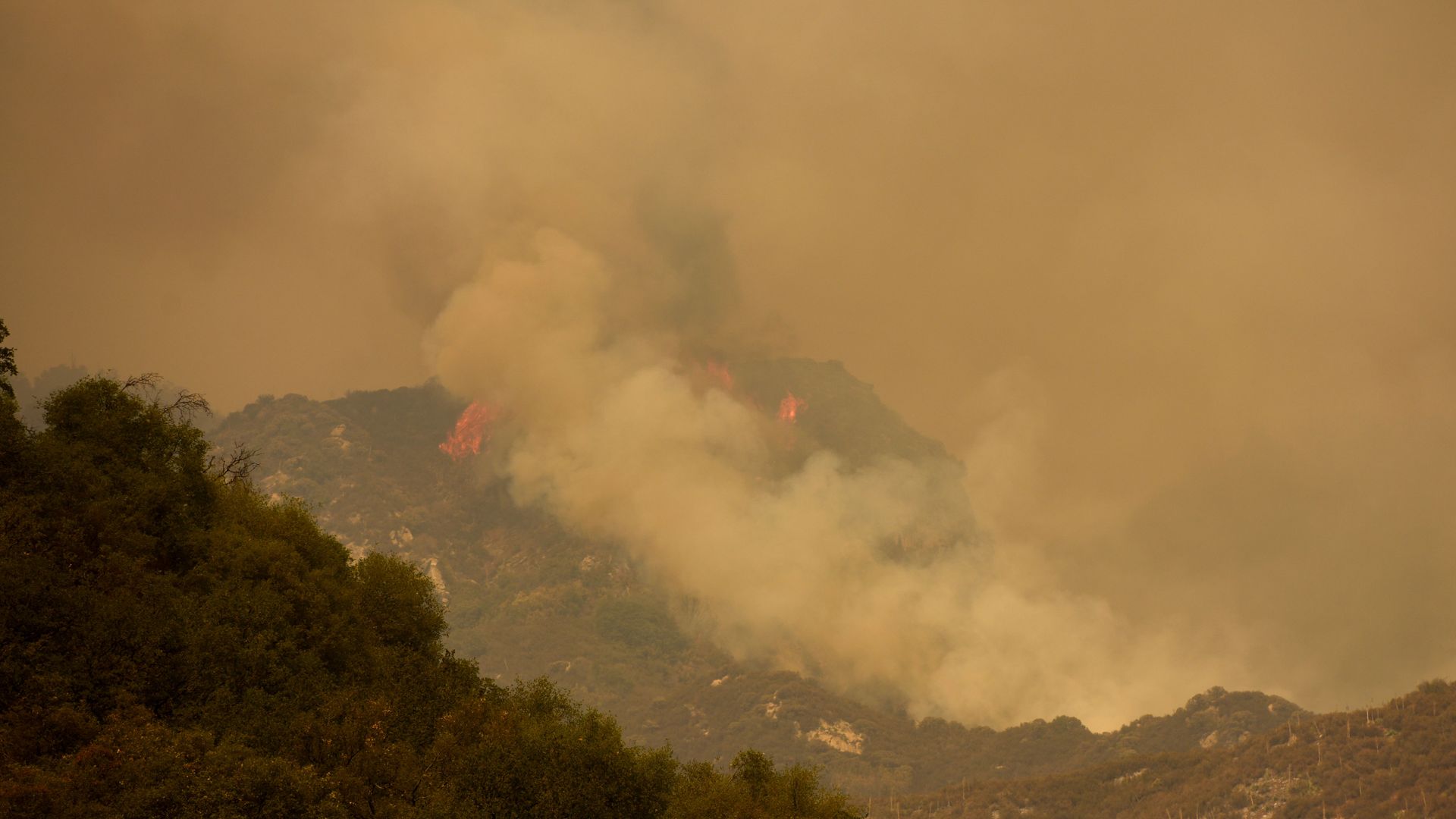 A plume of smoke and flames rise into the air as the fire burns towards Moro Rock during the KNP Complex fire in the Sequoia National Park near Three Rivers, California on September 18