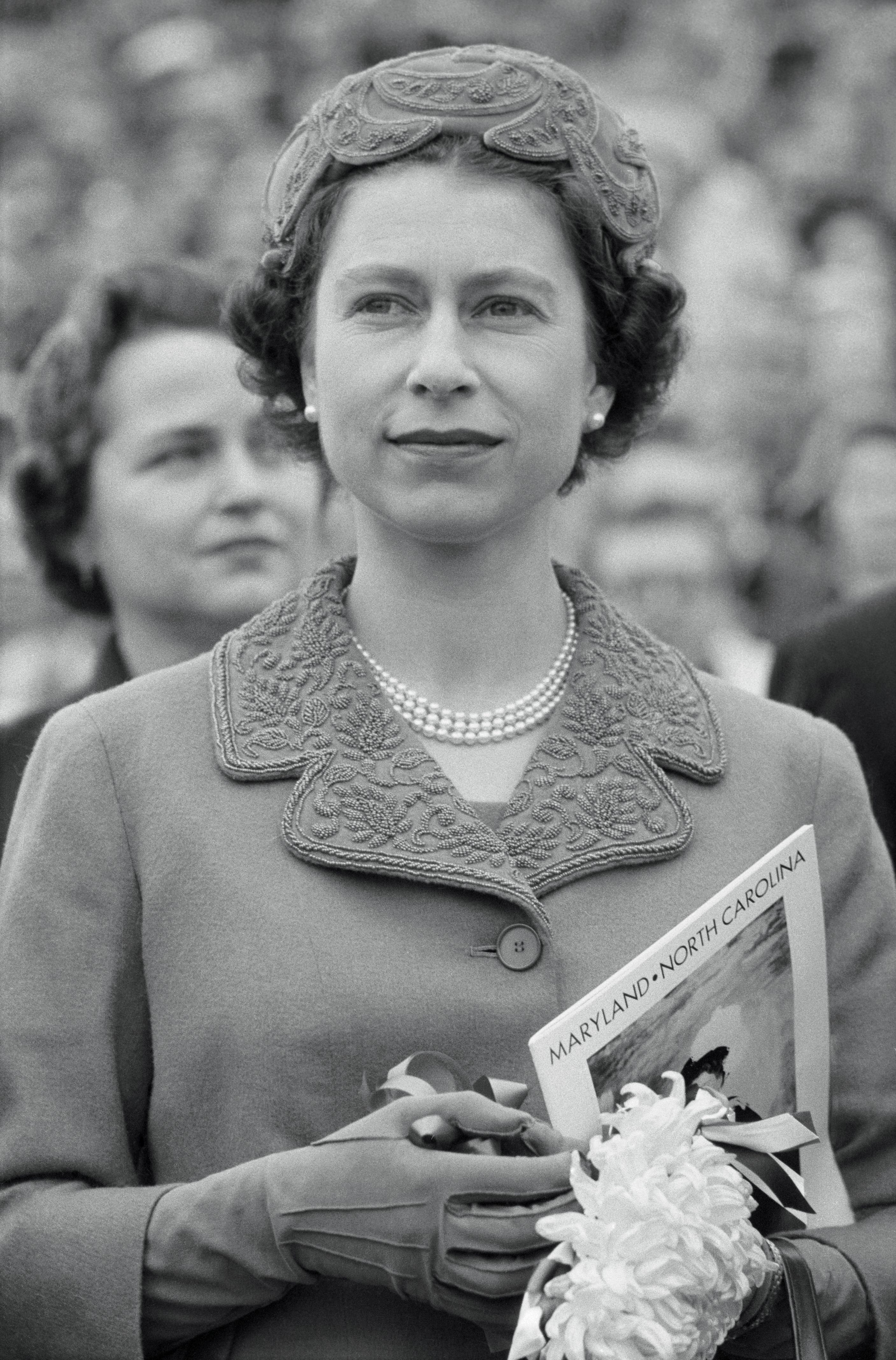 The queen holding a program for the North Carolina v. Maryland game in 1957. 