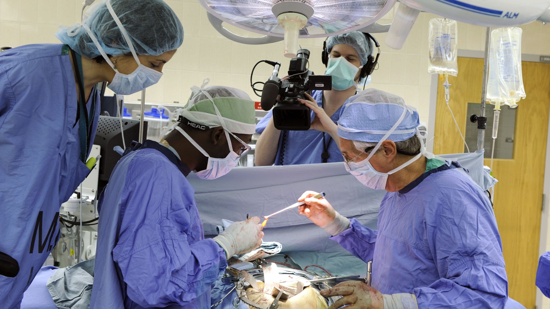 A camerawoman in scrubs films a surgery on ABC's Boston Med